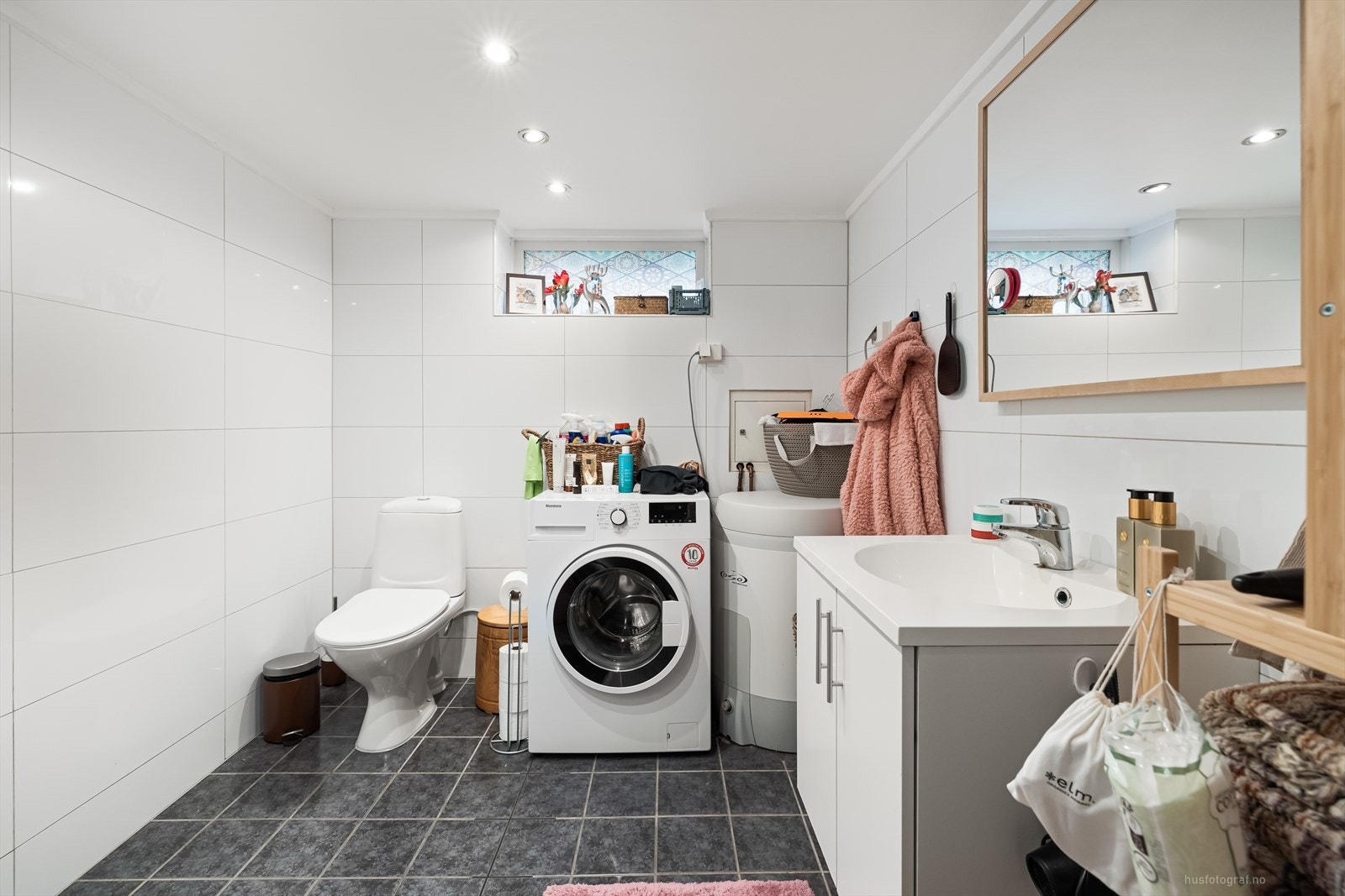 Pent bad i hybeldelen med elektrisk gulvvarme. Badet er utstyrt med dusjhjørne med innfellbare dusjvegger, toalett, nedfelt servant med rom for oppbevaring i underskap og speil. Rommet har opplegg for vaskemaskin. Galleribilde