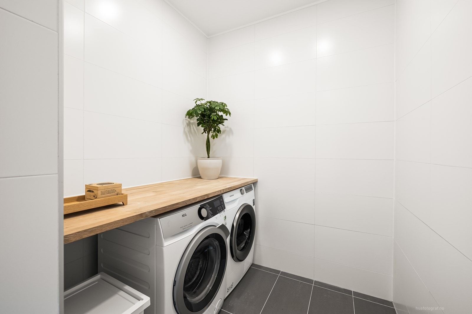 Det er laget en skillevegg på badet til innredningen med benkeplate og opplegg for vaskemaskin og tørketrommel. Galleribilde