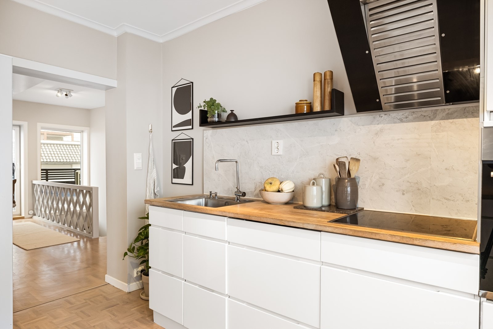 Lyse slette fronter, benkeplate av heltre og slett vegg med backsplash av laminat over kjøkkenbenken og gjennomtenkte detaljer. Galleribilde