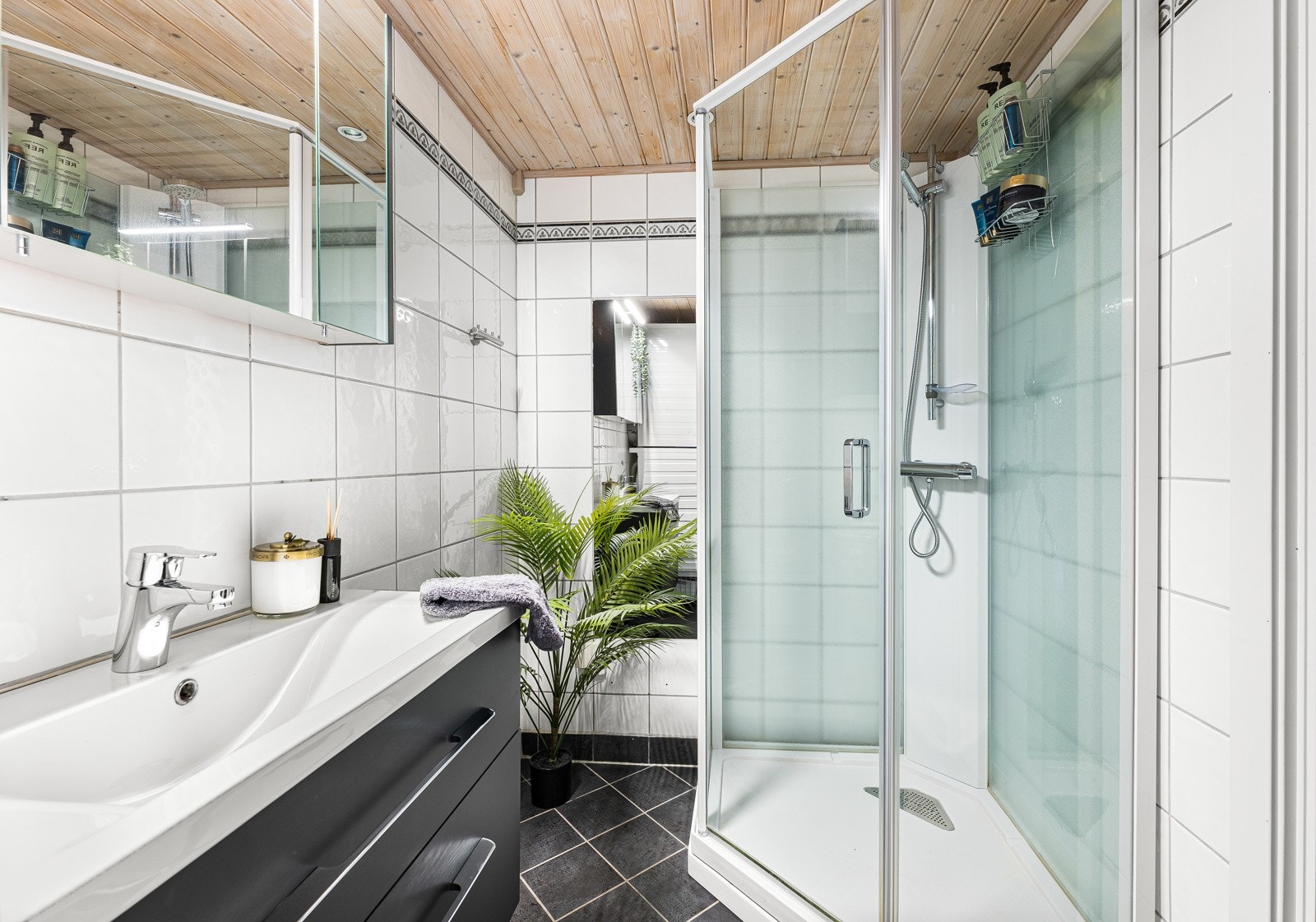 Bad og vaskerom med flislagte overflater, varmekabler i gulvet og downlights. Galleribilde