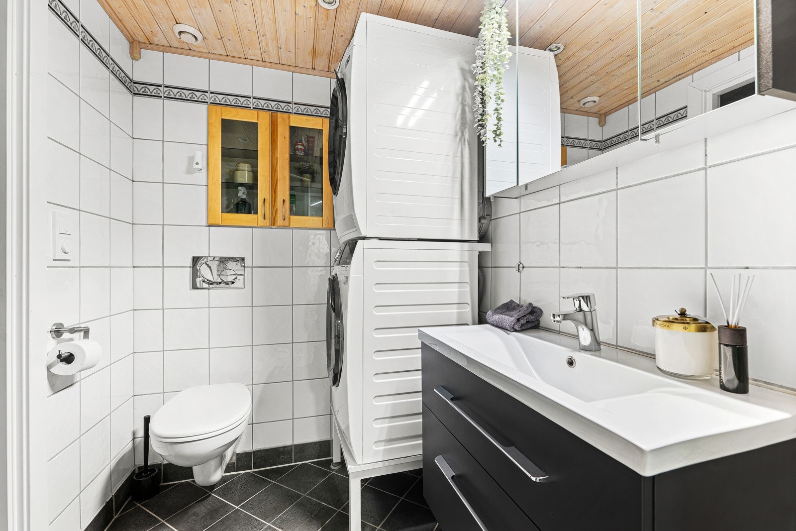 Badet har skuffeseksjon med nedfelt servant, speilskap, toalett, dusjkabinett og opplegg for vaskemaskin. Galleribilde