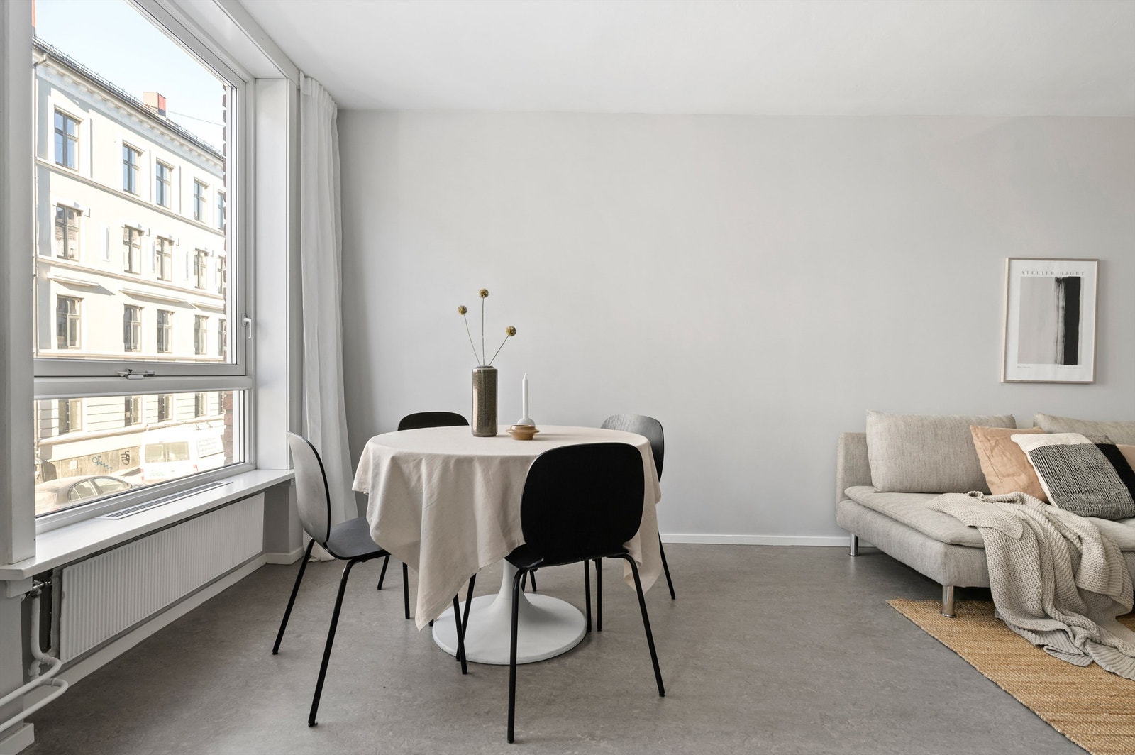 Det er store vindusflater som slipper inn rikelig med lys og skaper en lys og luftig atmosfære i stuen. Vakre klassiske bygg preger utsynet på andre siden av veien. Galleribilde