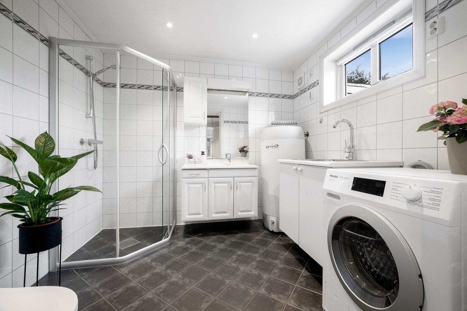 Boligen har to flislagte bad, ett i hver etasje - Dette er i 1.etasje og brukes også som vaskerom Galleribilde