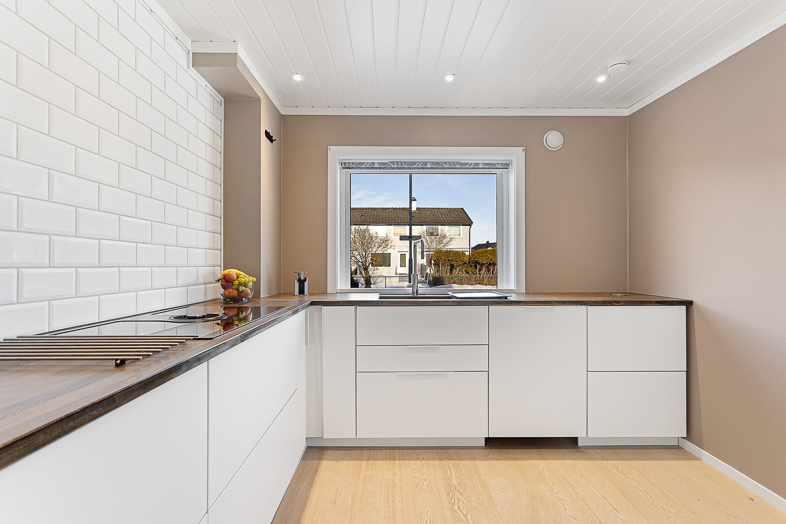 Kjøkken med innredning fra KVIK i slette fronter og benkeplate i heltre bøk. Innredningen er fra 2018 og har et moderne utrykk Galleribilde