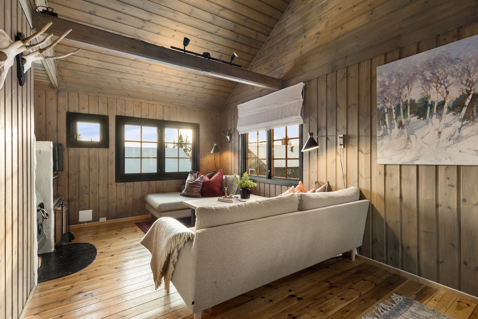 Allrommet som utgjør stue og kjøkken har originalt, lakkert furugulv og beiset panel på veggene. Galleribilde