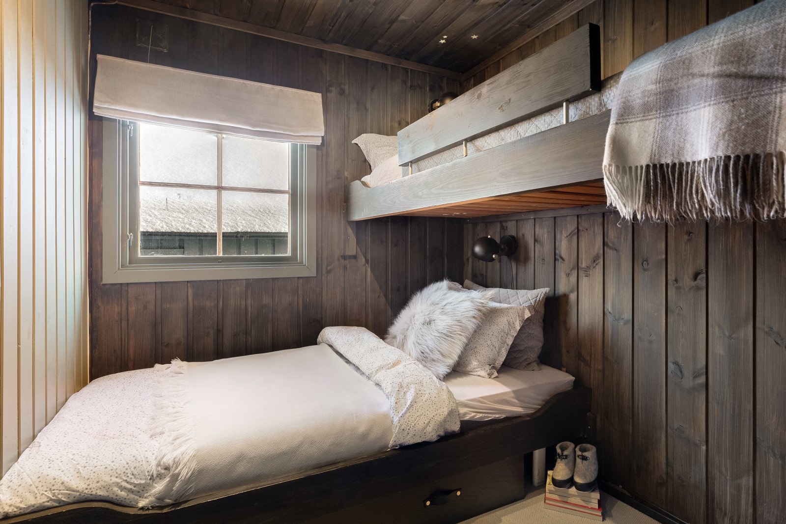 Hytten har to pene soverom i 1. etasje, begge med mørkbeiset panel på veggene. Galleribilde