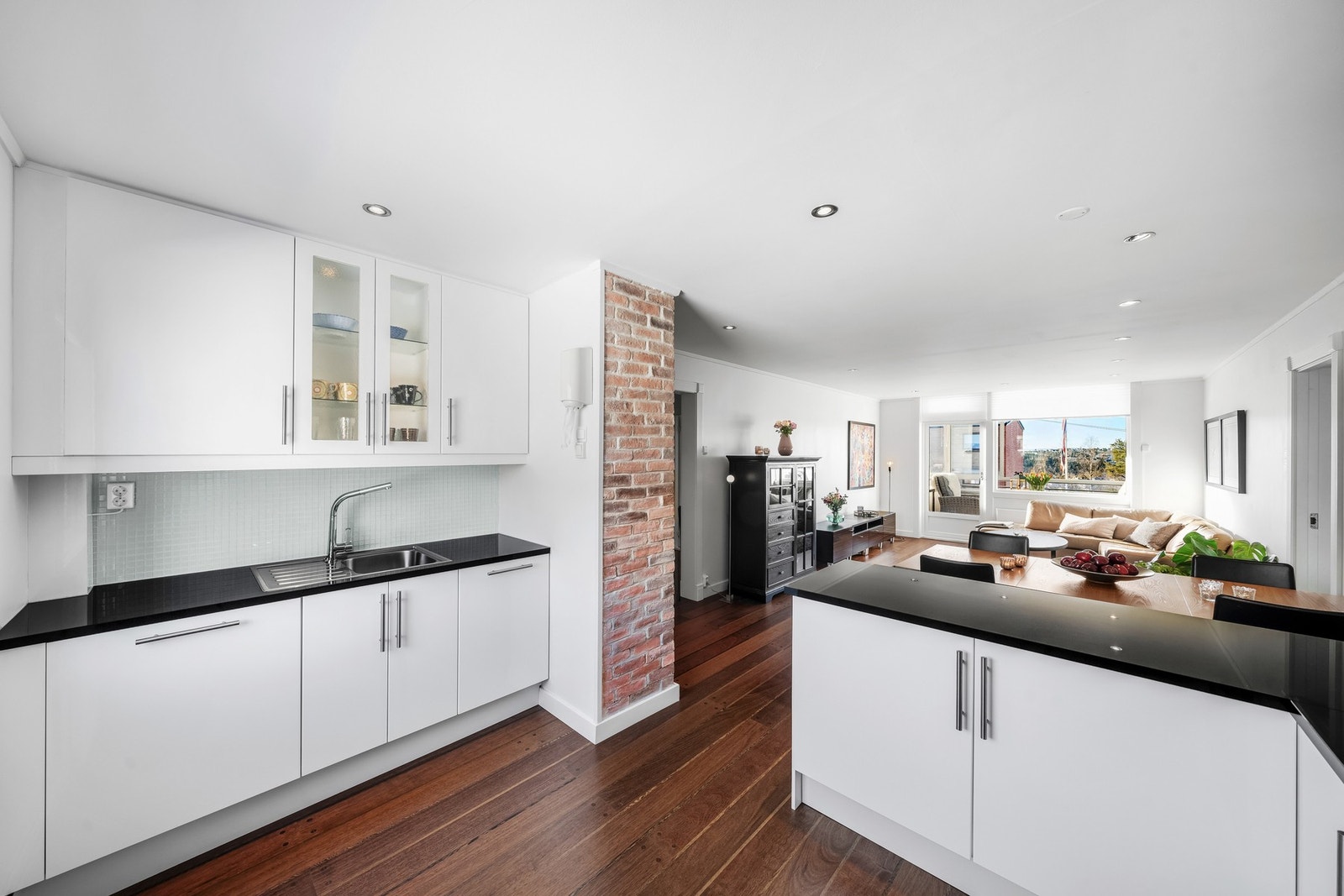 Tidligere vegg mellom stue og kjøkken har blitt åpnet opp delvis, for en mer luftig og sosial atmosfære. Galleribilde