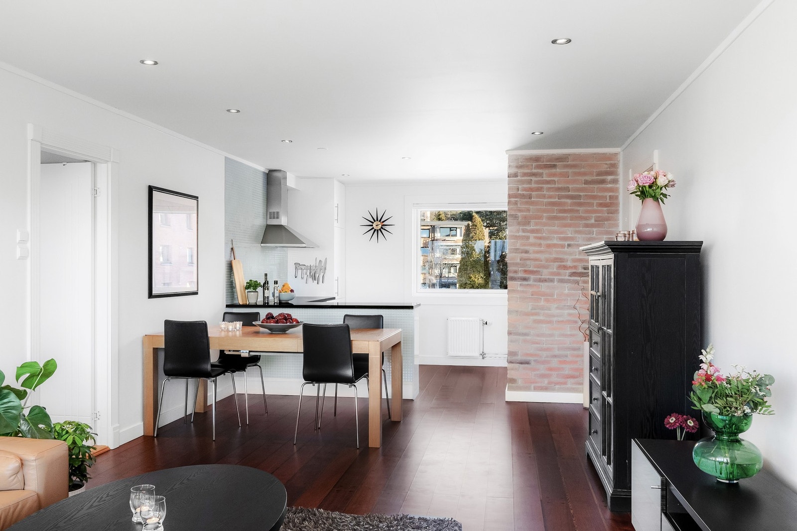 Den synlige teglsteinsveggen mellom stue og kjøkken gir et sjarmerende særpreg til boligen. Galleribilde