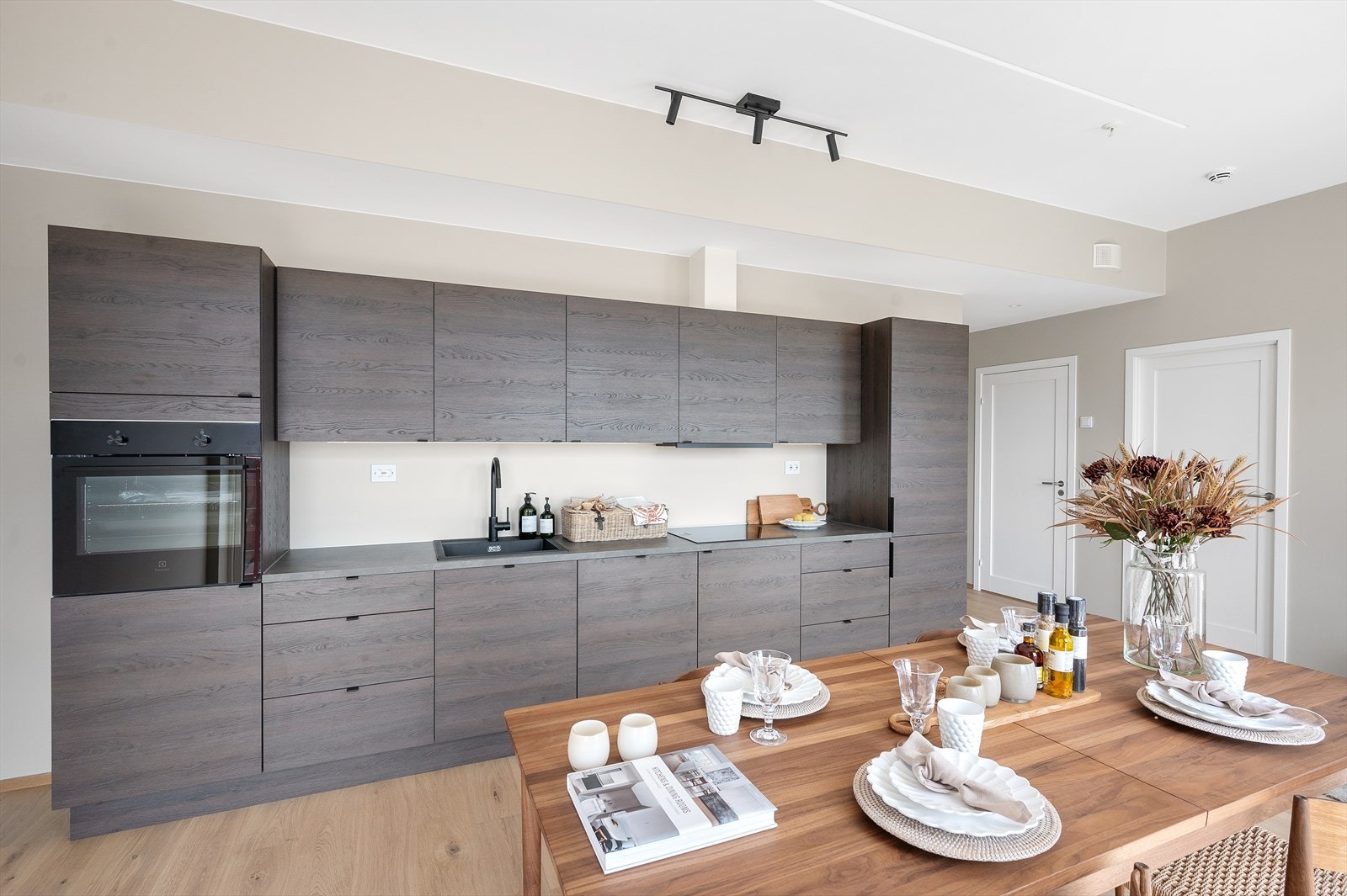 Kjøkkenet har innredning fra Strai med integrerte hvitevarer som inkluderer induksjonstopp, ventilator, komfyr og kombinert kjøl- og fryseskap. Galleribilde