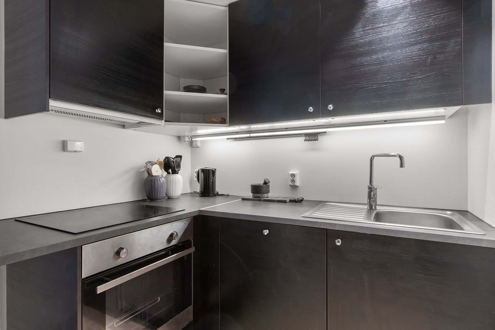 Innredning fra Ikea med glatte fronter, malte plater på veggen over kjøkkenbenken og benkeplate i laminat. Galleribilde