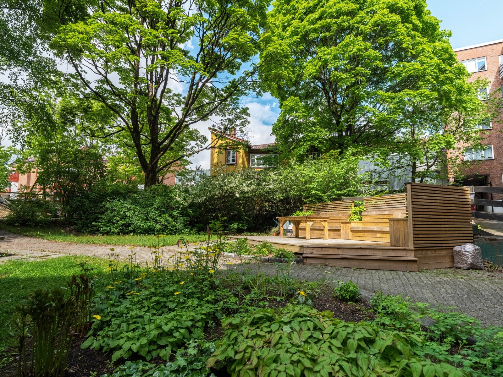 Gårdsrommet er ellers opparbeidet med belegningsstein, gressplen og beplantning. Galleribilde