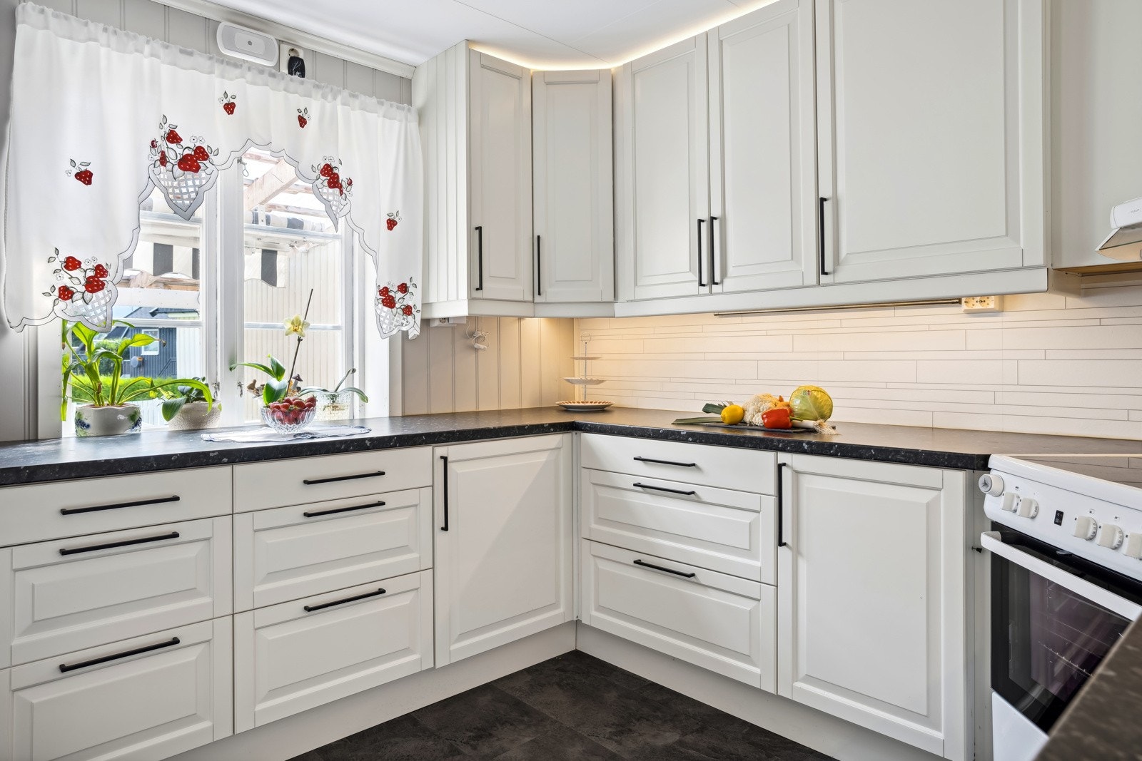 Kjøkken utstyrt med frittstående komfyr, oppvaskmaskin, kjøleskap med fryser og integrert stekeovn. Galleribilde