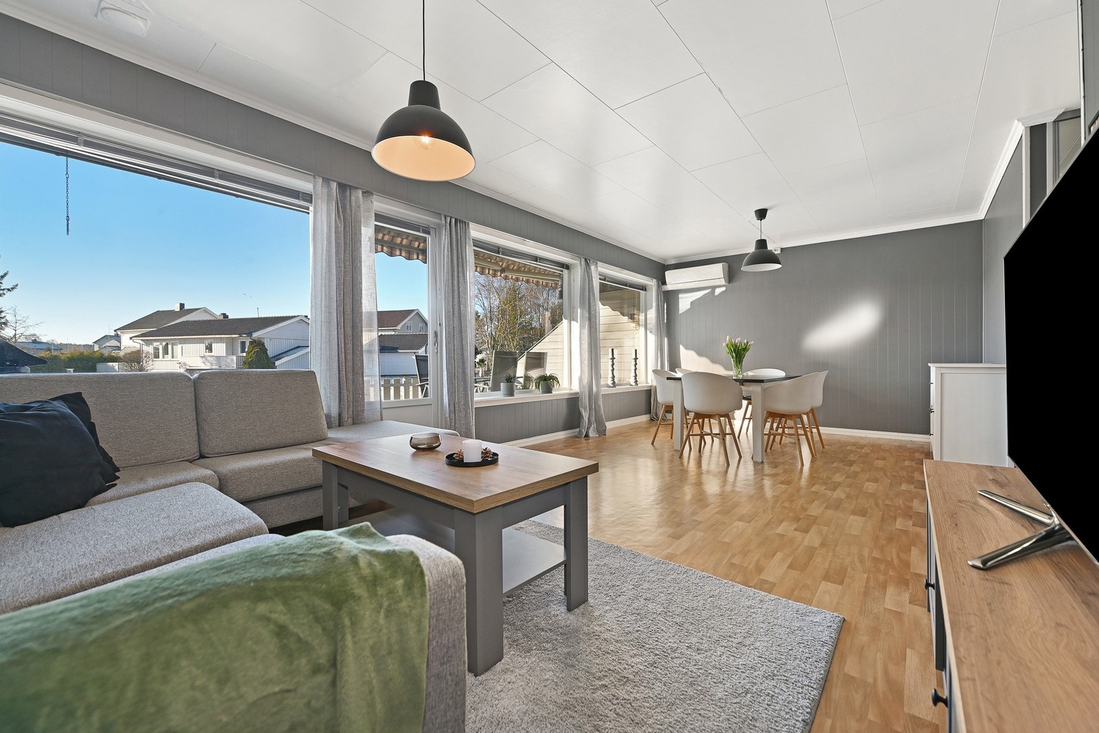 Stuen har store vinduer som gir mye naturlig lys og utsikt. Rommet har gråmalte vegger. Det er god plass til både sofagruppe og spisebord. Galleribilde