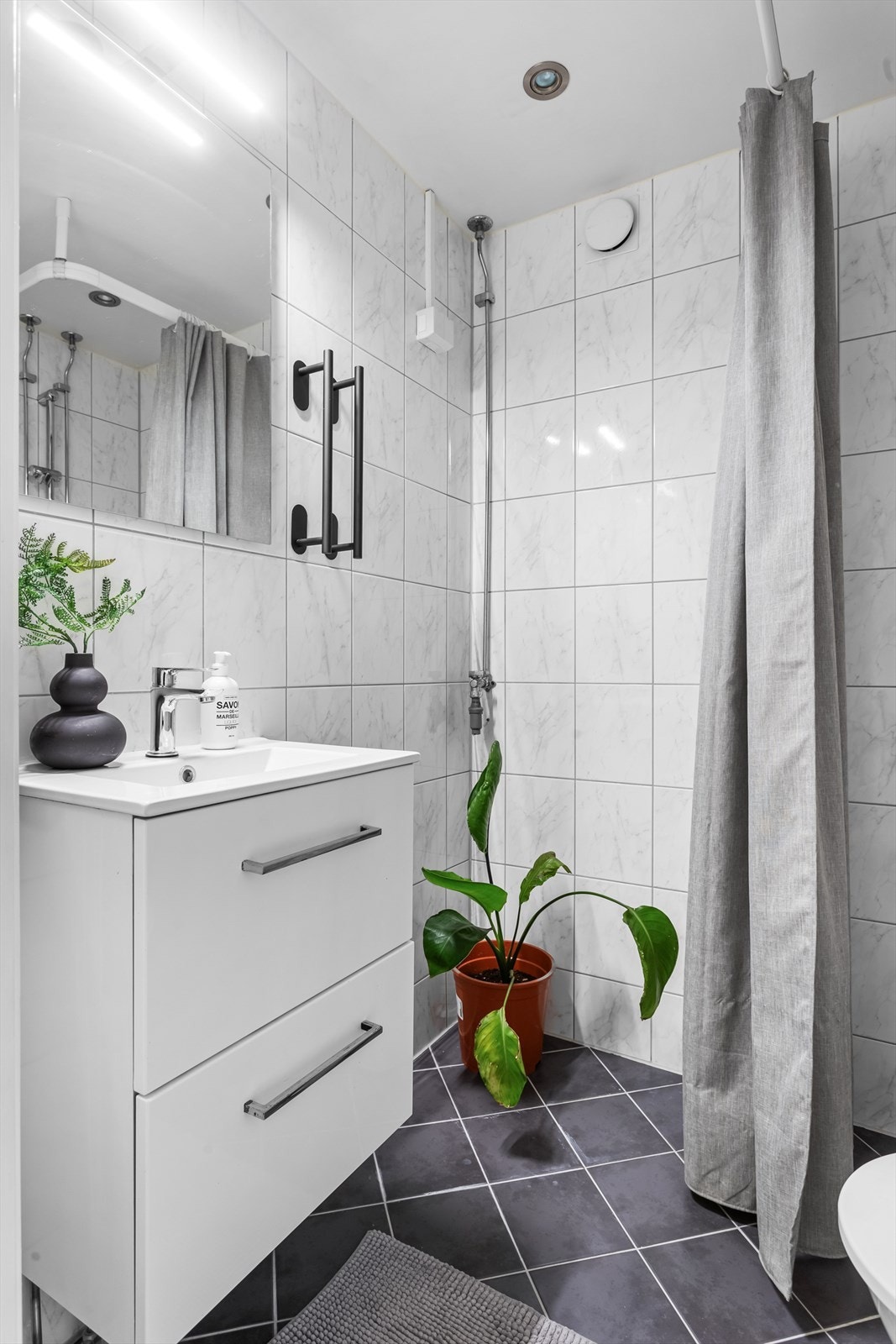 Videre har badet innredning med servant og opplegg for vaskemaskin. Galleribilde