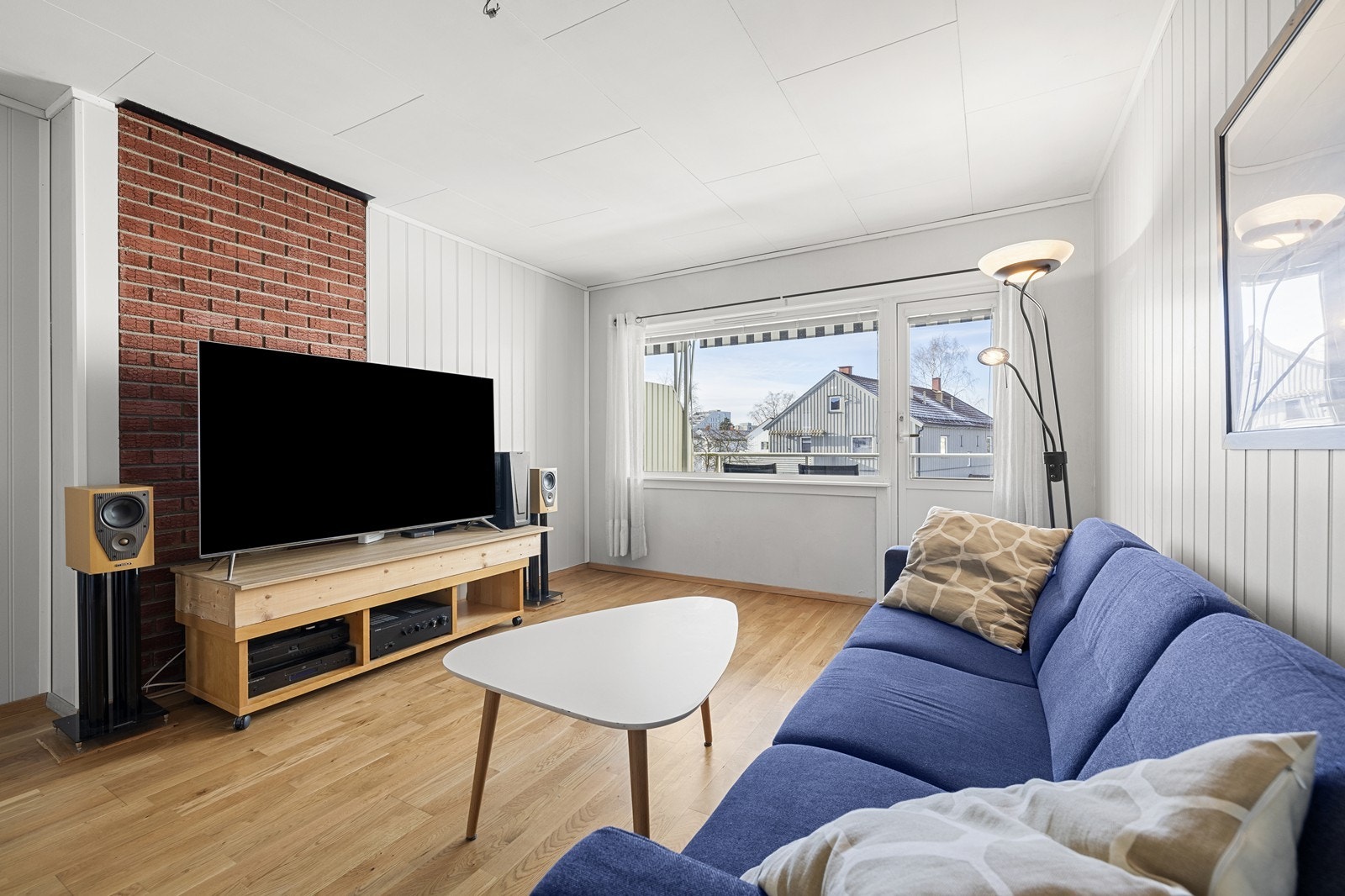 Lys stue med stor vindusflate og utgang til balkong. Galleribilde