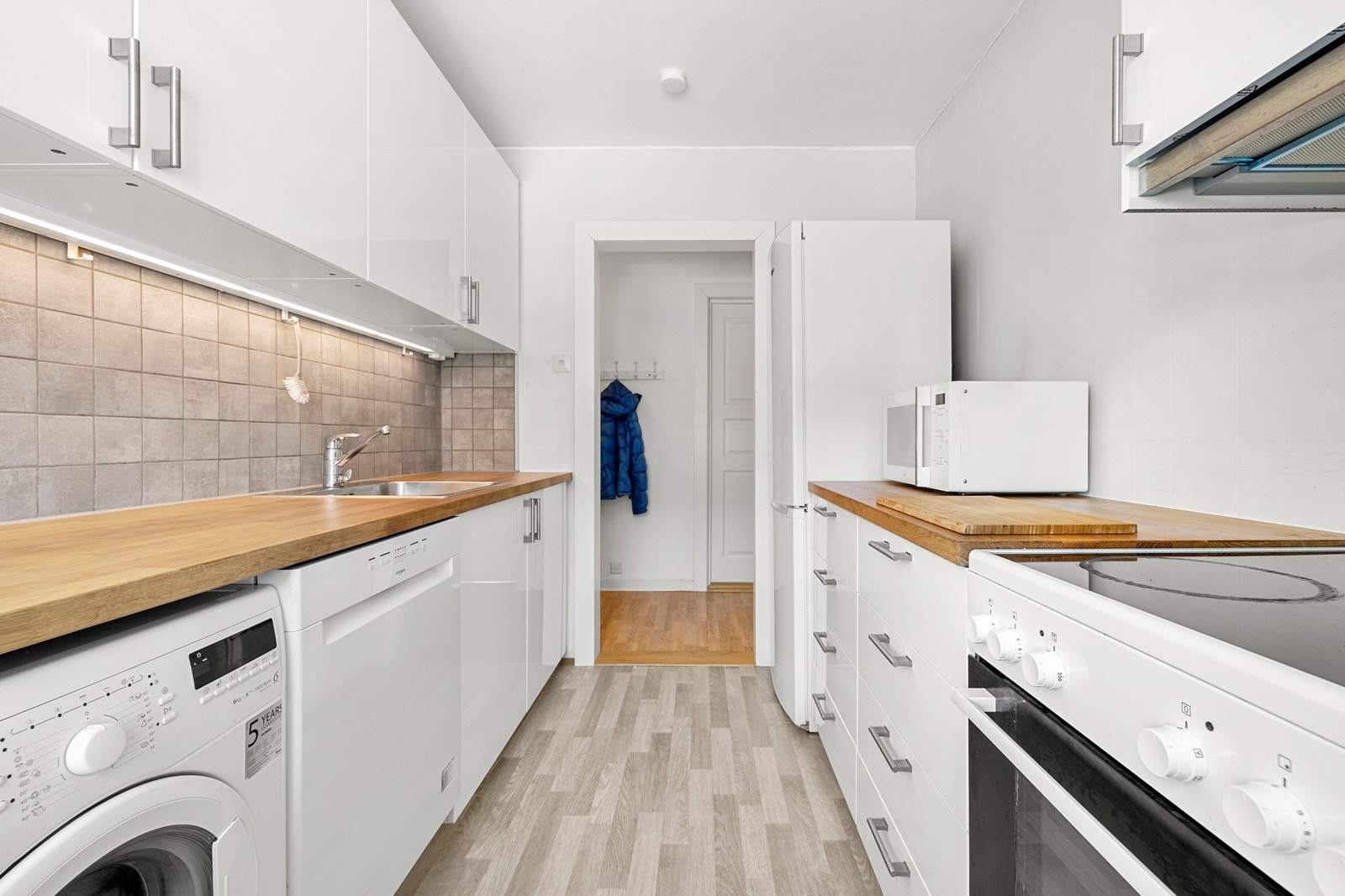 Integrerte hvitevarer som koketopp og stekeovn. Frittstående kjøle-/fryseskap, oppvaskmaskin, samt opplegg for vaskemaskin. Galleribilde