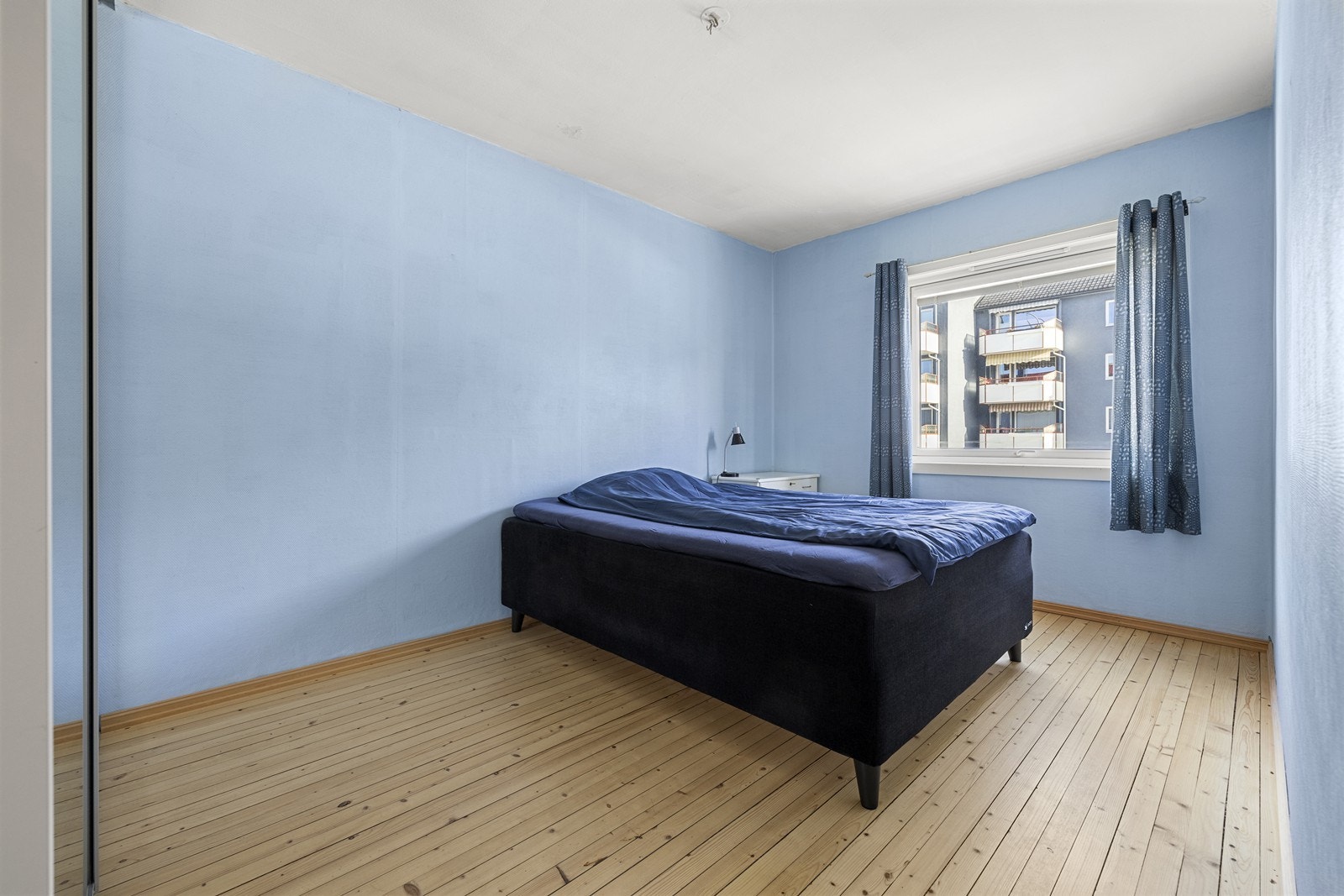 Romslig soverom med tregulv og malte overflater. Soverommet har garderobeløsning og fin vindusflate som slipper inn rikelig med naturlig lys. Galleribilde