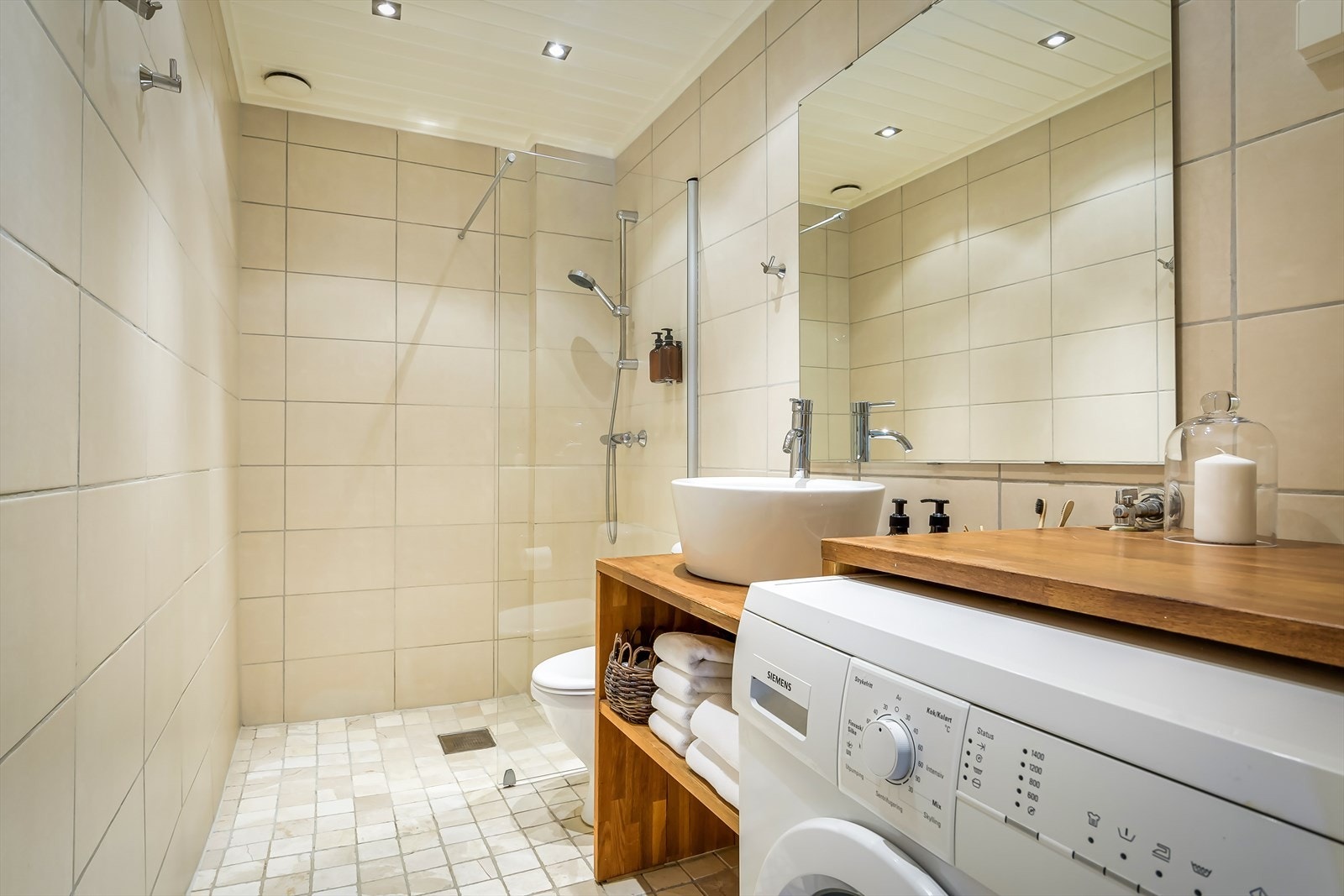 Romslig baderom med varmekabler og opplegg for vaskemaskin. Galleribilde