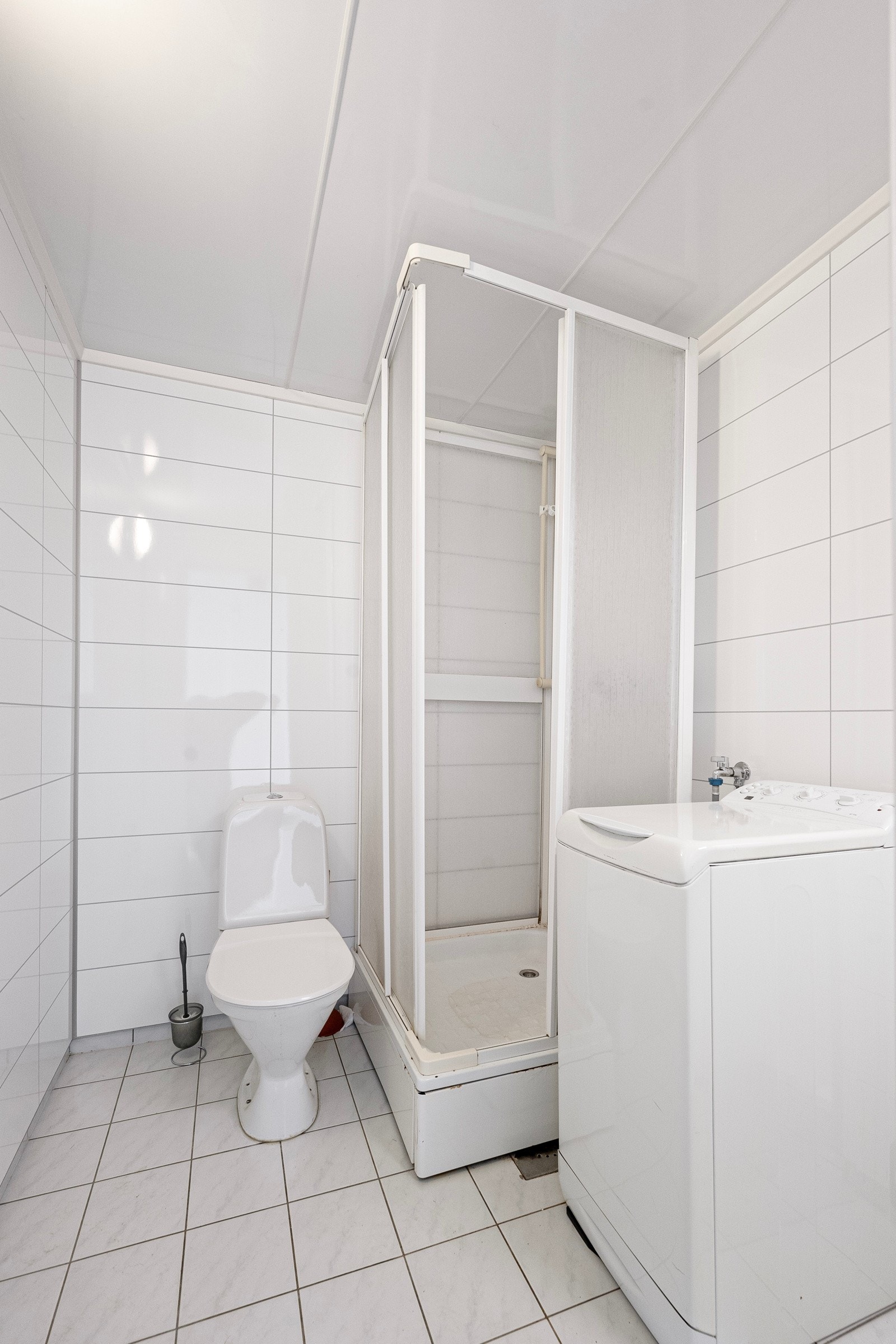 Badet i 1. etasje har servant i innredning, overskap med speil, dusjkabinett og gulvmontert toalett. Opplegg for vaskemaskin Galleribilde