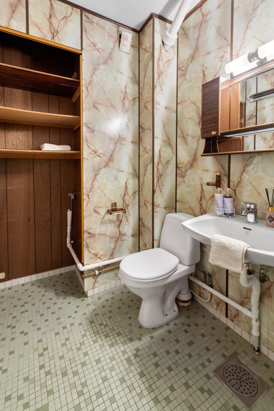 Badet er innredet med dusjkabinett, servant, gulvstående klosett og opplegg for vaskemaskin. Galleribilde