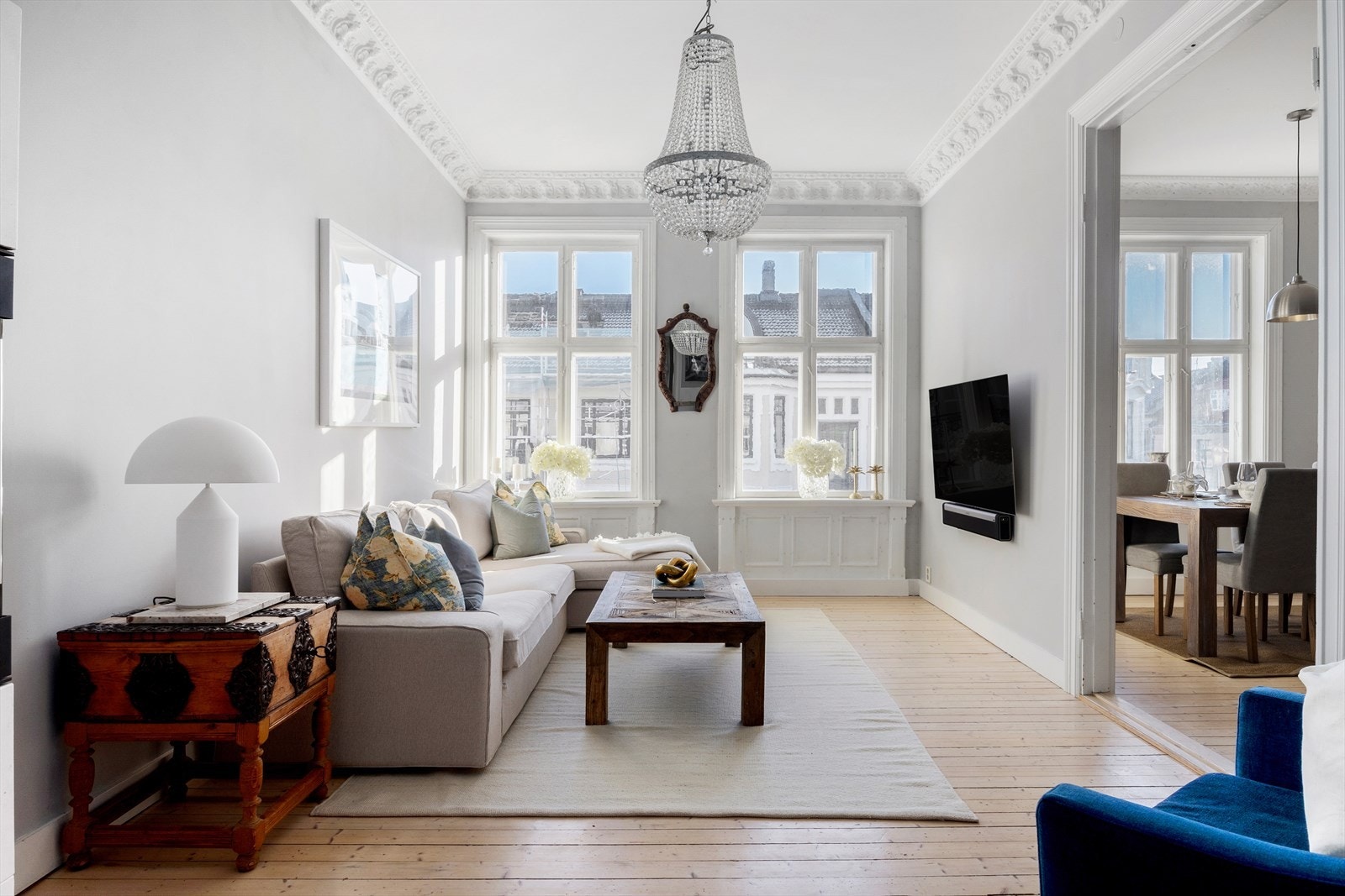 Lys og innbydende stue med originale tregulv og klassiske detaljer som stukkatur og rosett. Galleribilde
