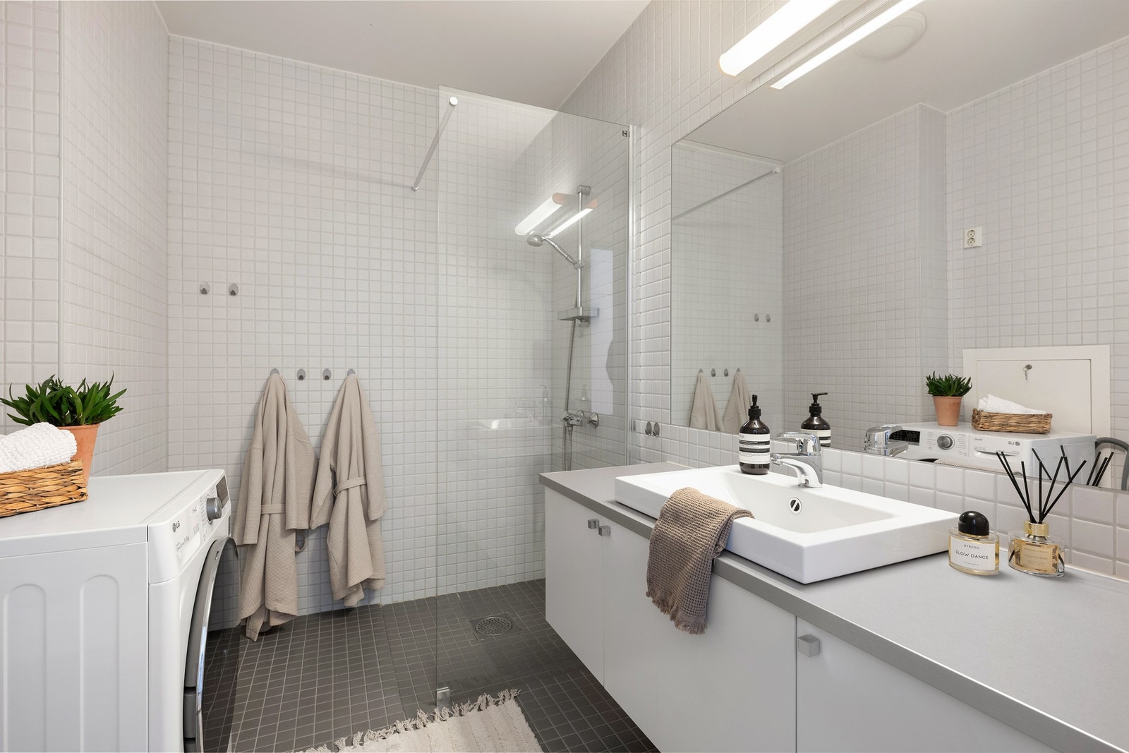 Badet er romslig med vegghengt toalett, dusjhjørne og opplegg for vaskemaskin. Galleribilde