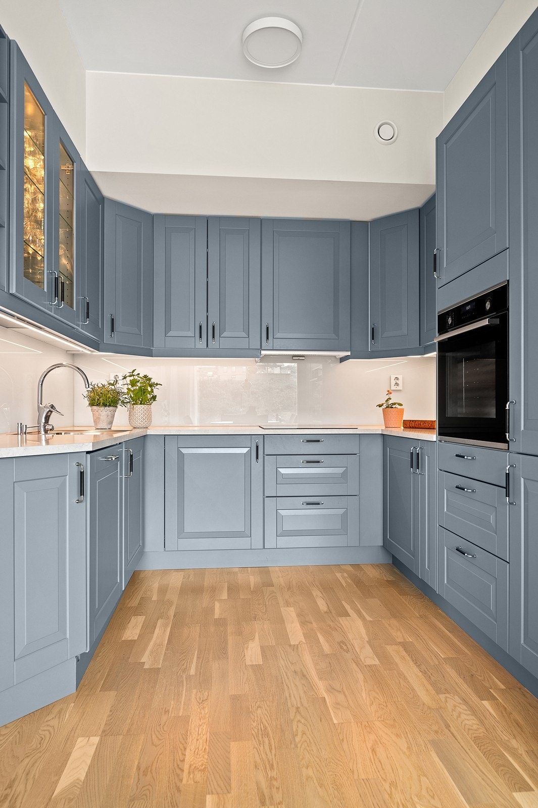 Godt med arbeidsplass på kjøkkenbenk, som er opplyst av LED-lys montert på undersiden av kjøkkenskapene Galleribilde