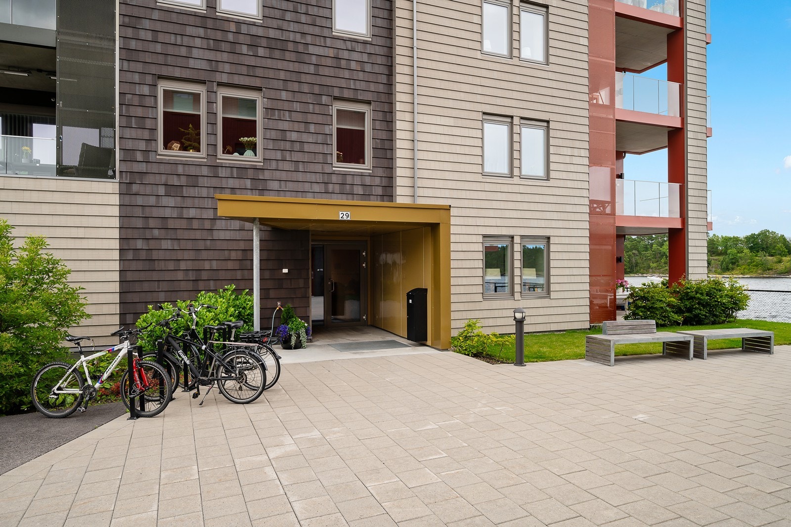 Felles overbygget inngangsparti. Pent opparbeidet med heller, sitteområde og gressplen Galleribilde