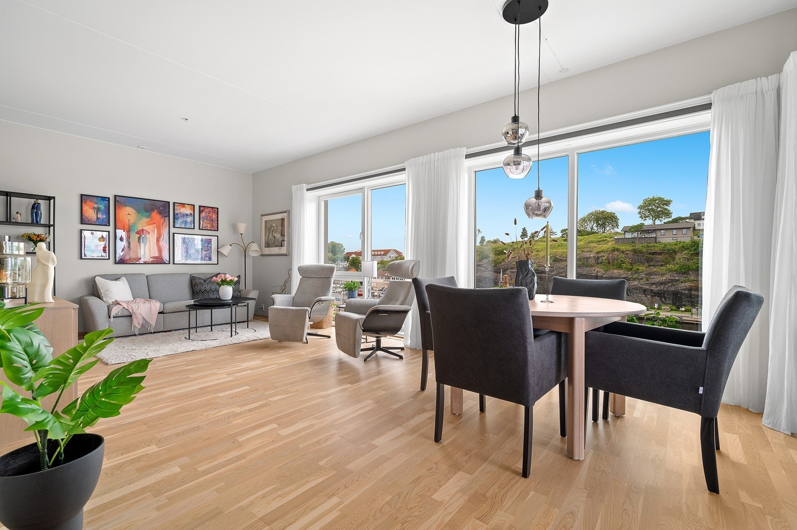 Romslig stue med god takhøyde og store vindusflater som slipper inn rikelig med naturlig lys i leiligheten Galleribilde