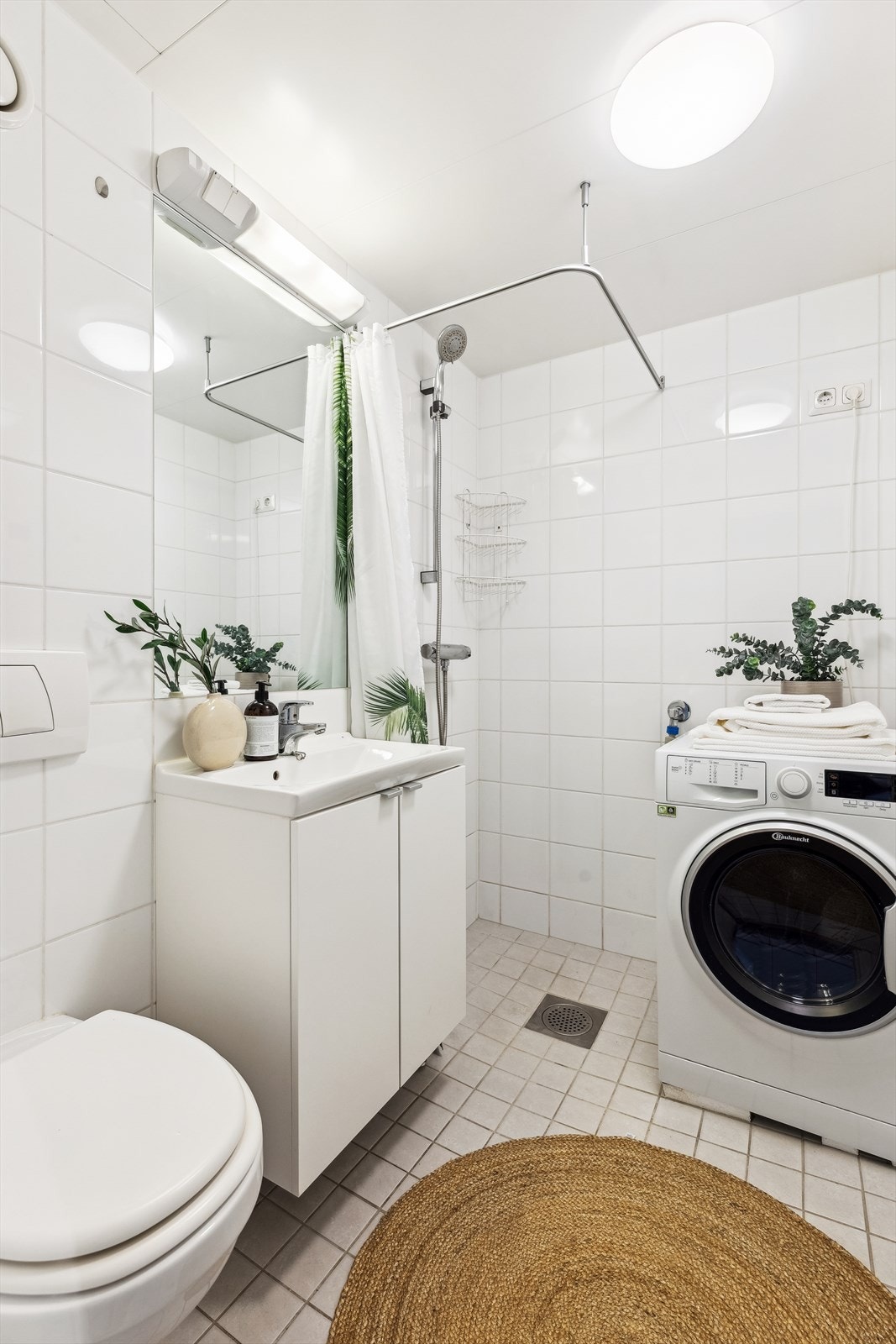 Flislagt baderom med opplegg for vaskemaskin. Galleribilde