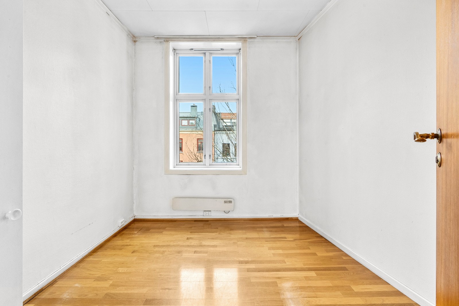 Leiligheten har et lyst soverom med stort vindu og lysmalte veggflater. Galleribilde