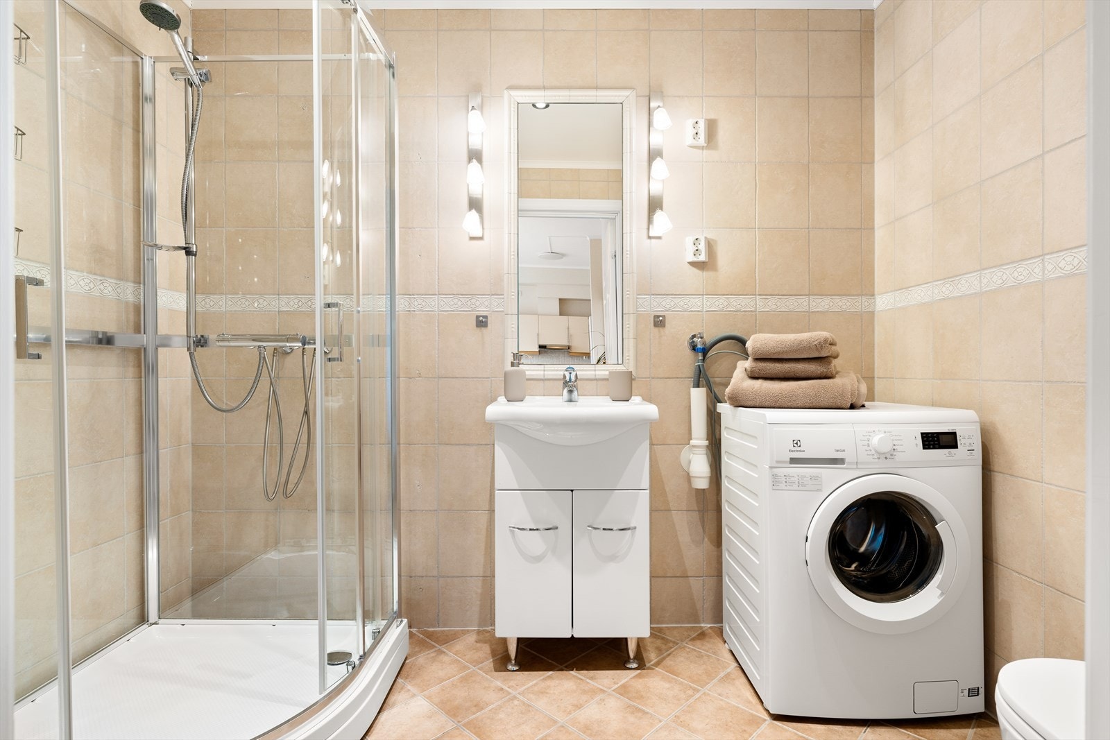 Baderommet er på ca. 4,3 kvm med fliser på gulv og vegger. Galleribilde