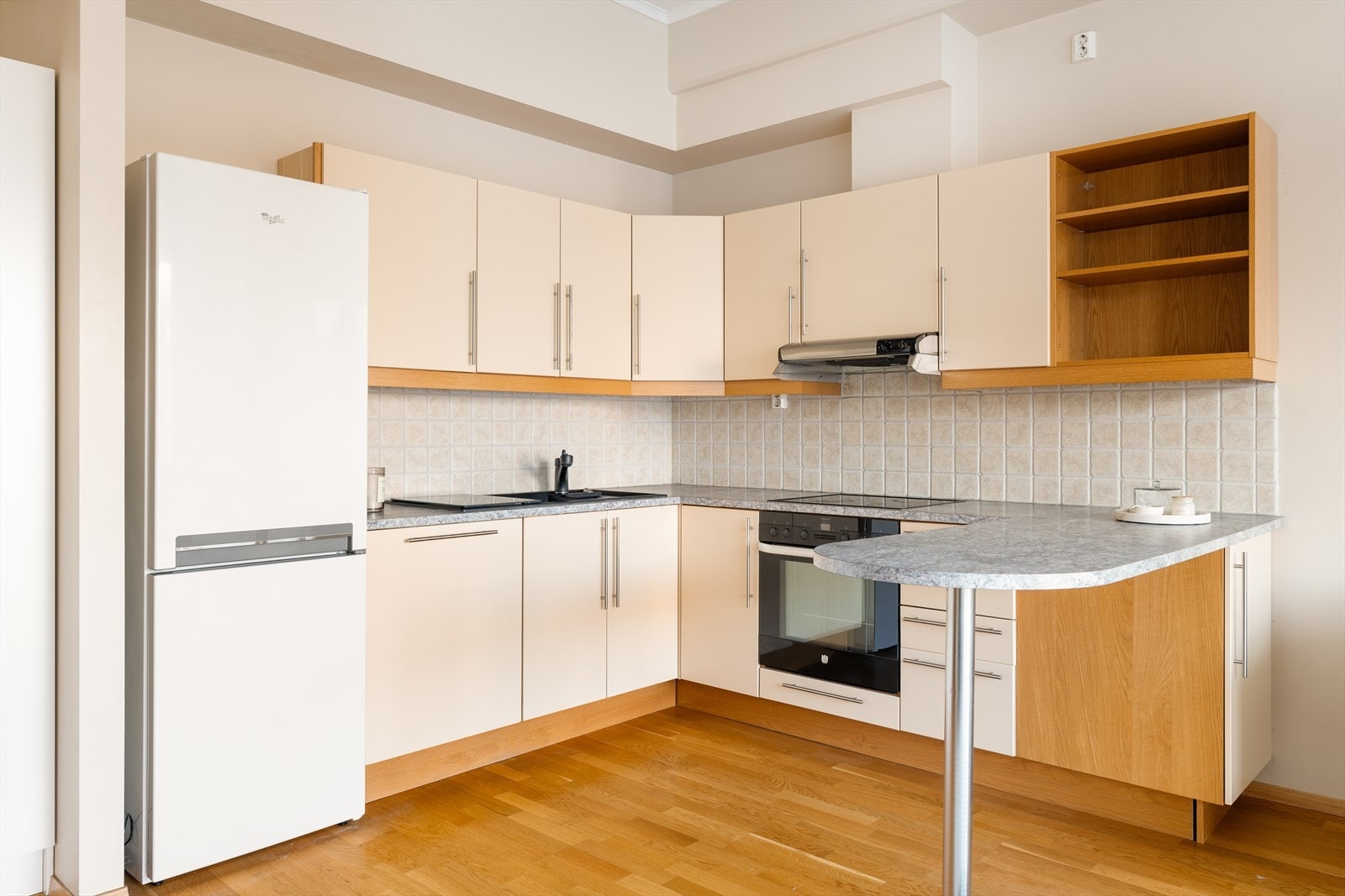 Kjøkkenet har en praktisk løsning som gir ekstra godt med skap og benkeplass. Galleribilde