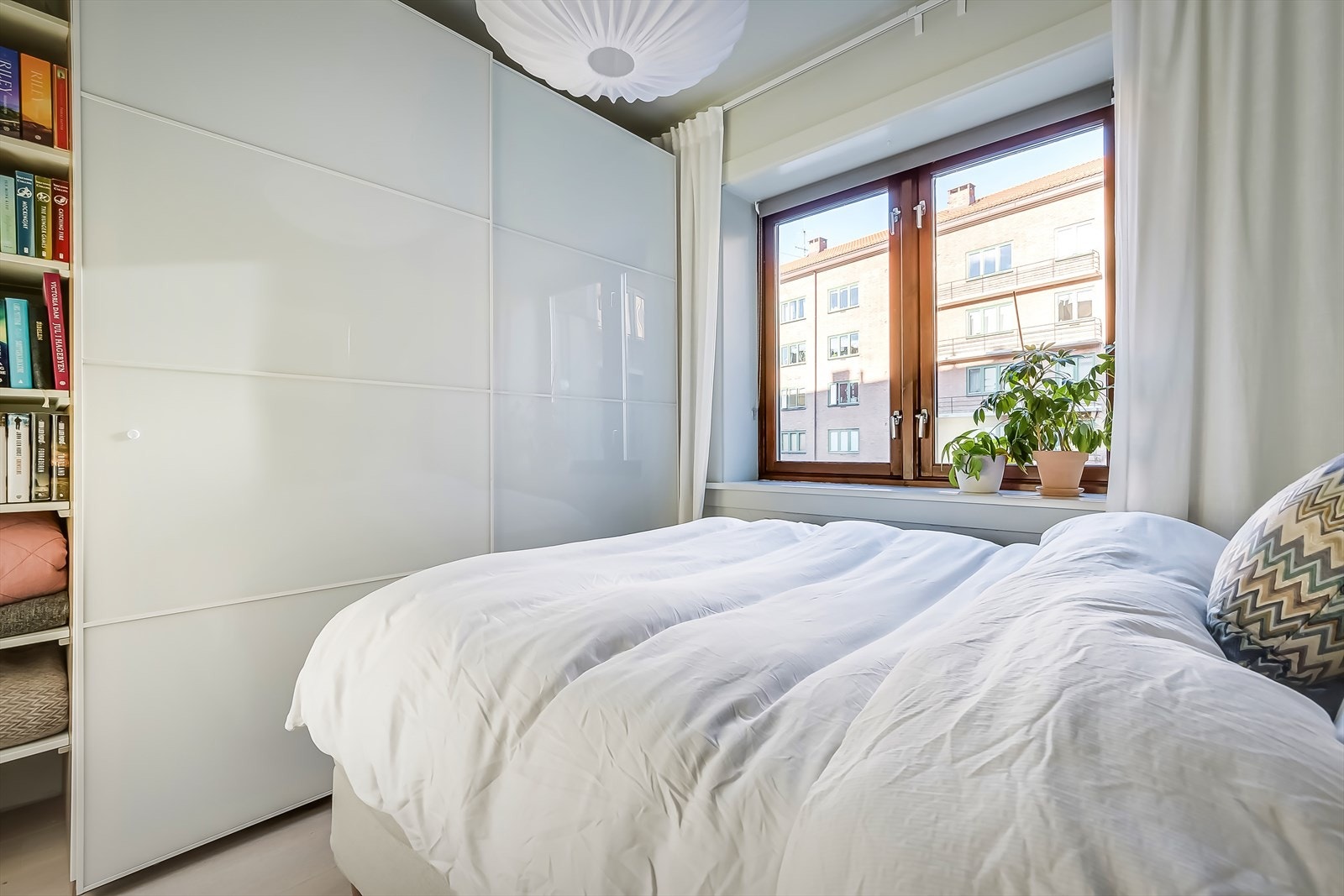 Soverommet er innredet med garderobeskap med skyvedører og en plassbygd hylle for oppbevaring. Galleribilde