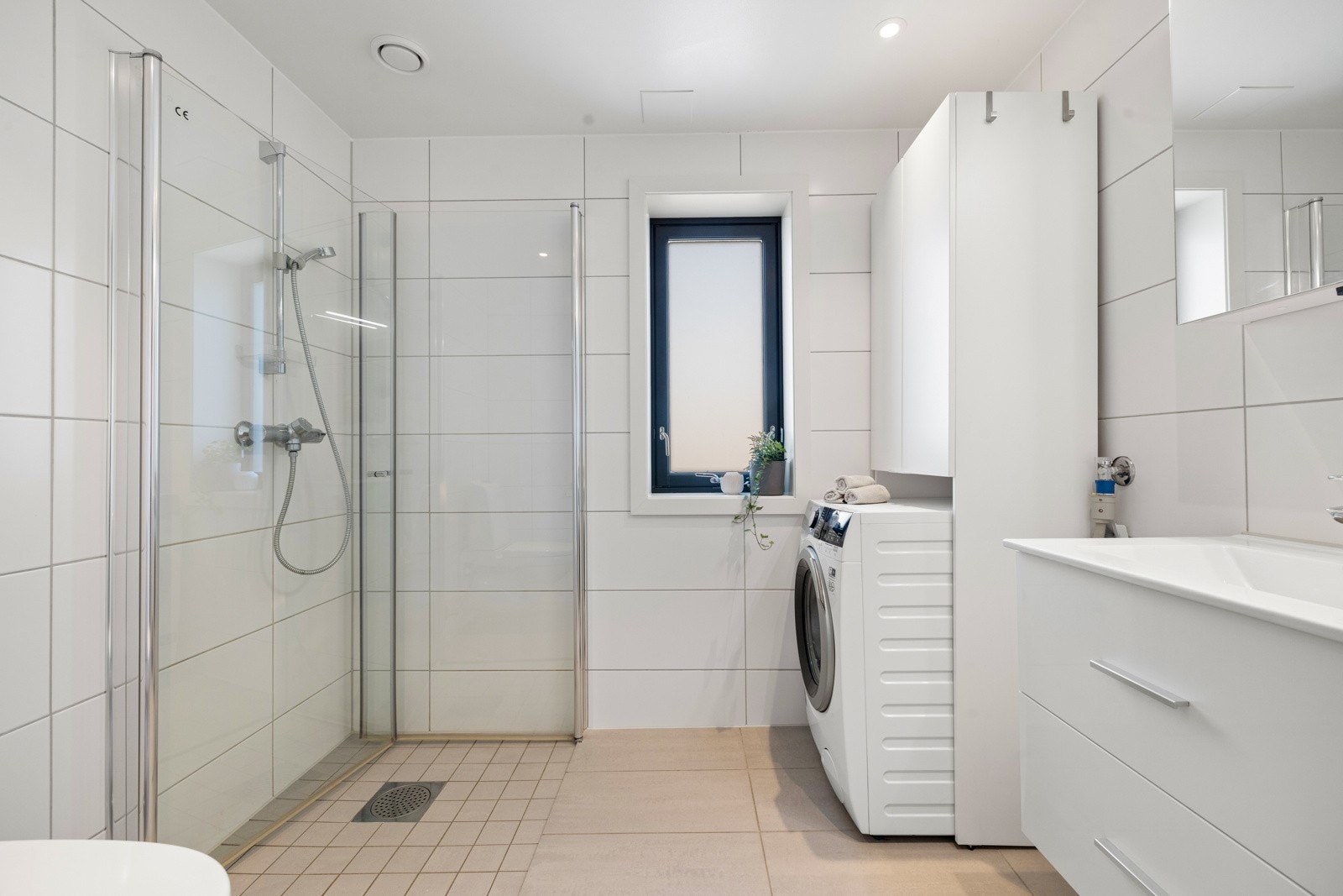 Pent, flislagt baderom med flislagt gulv, behagelig gulvvarme, vindu med frostet glass og downlightsbelysning. Galleribilde