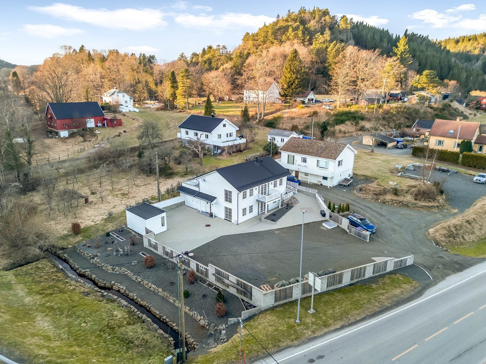 Pent opparbeidet eiendom med beplantet område på utsiden av et inngjerdet område som rammer inn eiendommen på en fin måte. Galleribilde