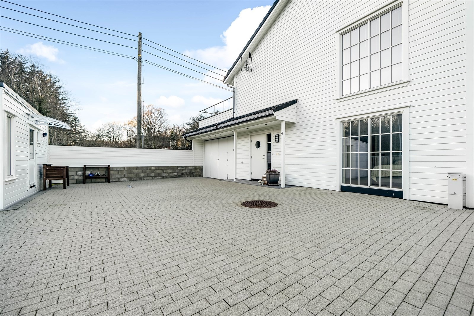 Steinlagt uteområde med mye boltreplass og møbleringsmuligheter med utemøblement. Galleribilde