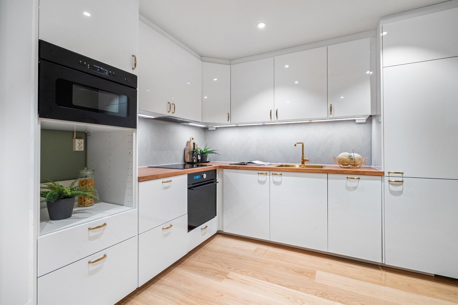 Kjøkkeninnredning består av glatte, hvite fronter. Laminat benkeplate med nedfelt vask. Galleribilde