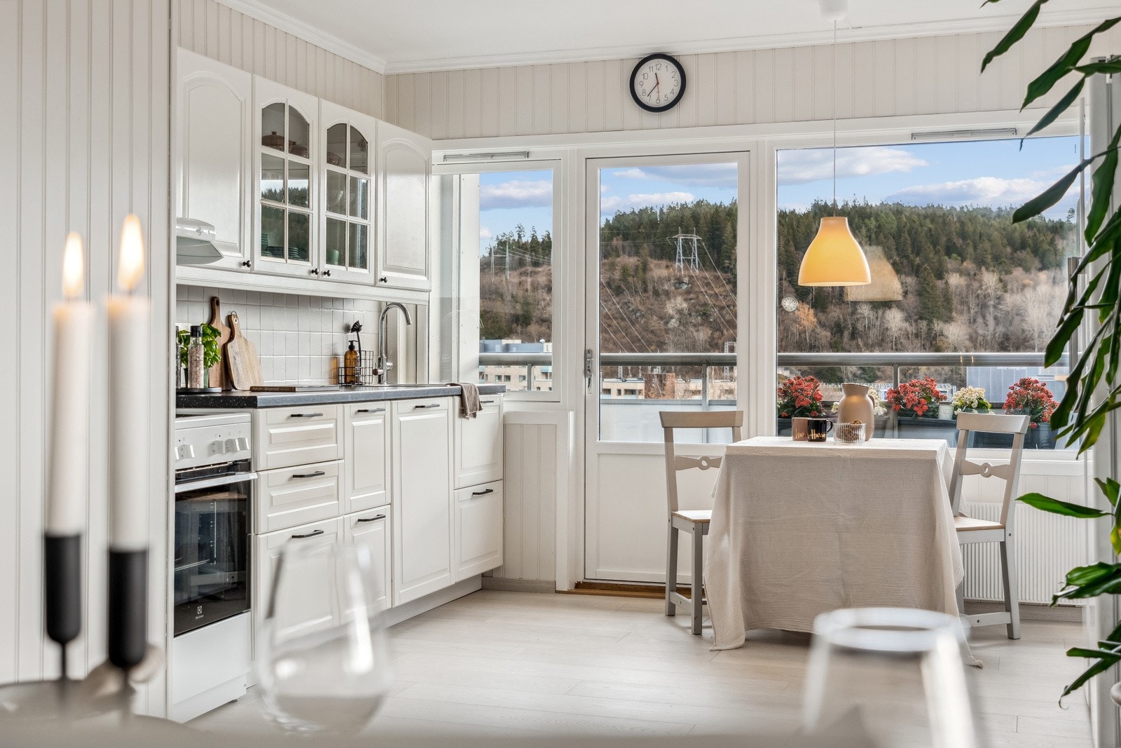 Kjøkkenet er delvis adskilt fra stuen og er innredet med hvite over- og underskap med en benkeplate i kontrastbasert fargevalg. Galleribilde