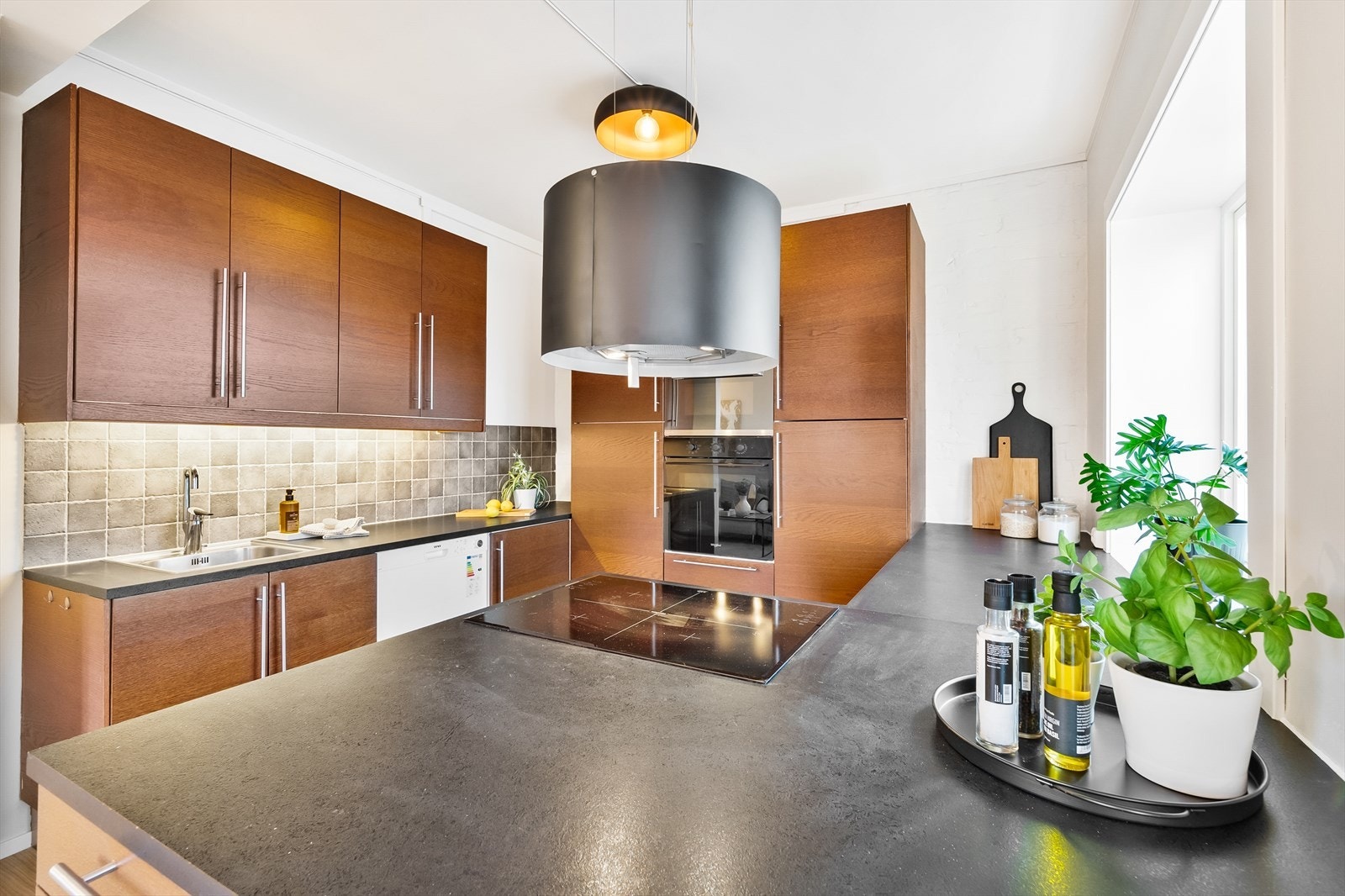 Pent kjøkken med mye skap- og benkeplass. Kjøkkeninnredning fra IKEA montert i 2013 med glatte laminerte fronter og laminert benkeplate som har overliggende oppvaskkum med ett greps blandebatteri fra Oras. Galleribilde