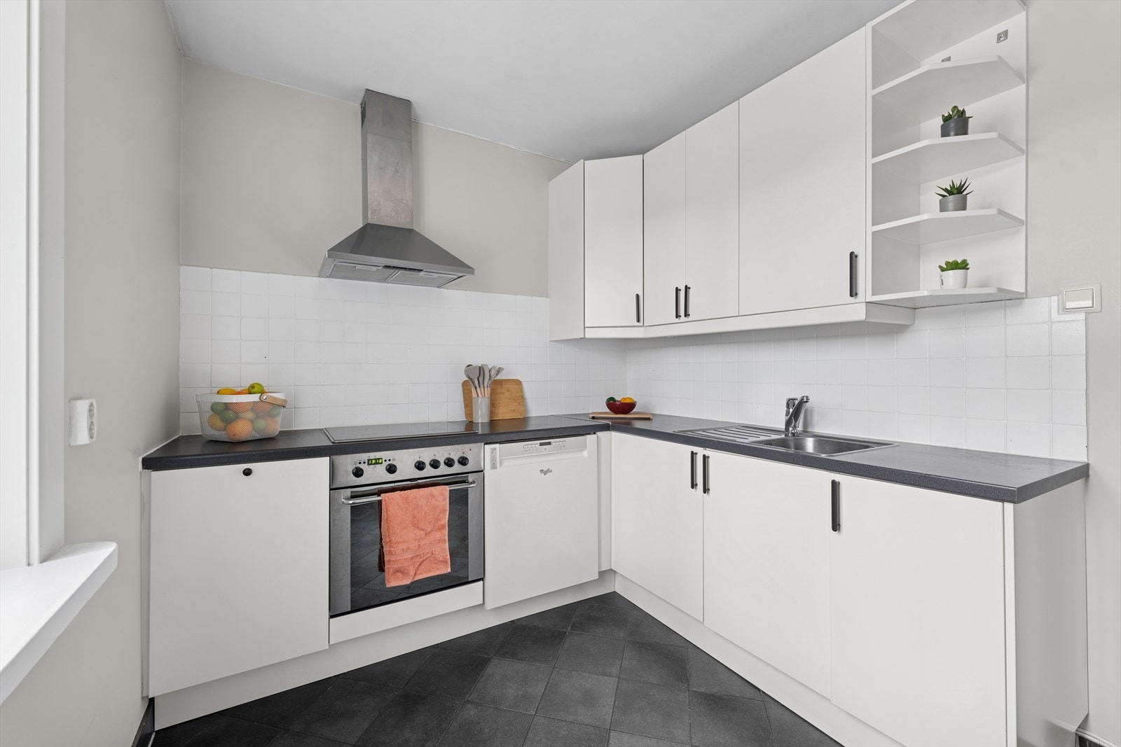 Kjøkkeninnredningen består av glatte hvite fronter og laminat benkeplate. Galleribilde