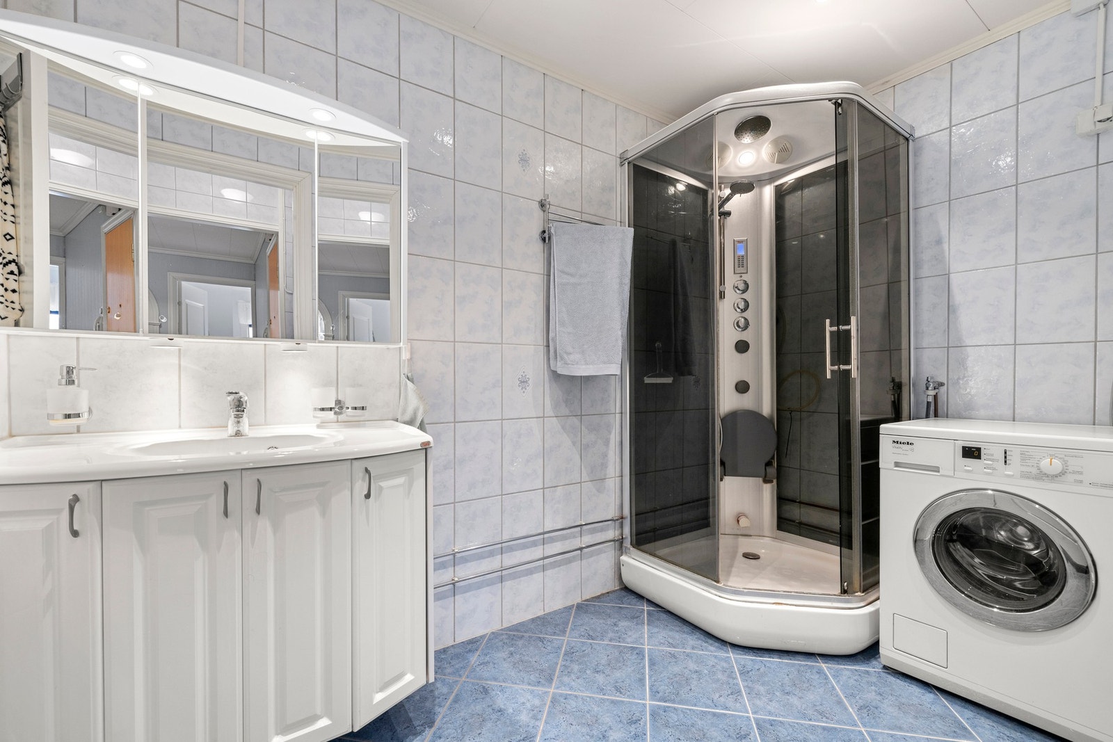 Badet har gulvvarme, vegghengt servantskap og et dusjkabinett med dusjarmatur. Galleribilde