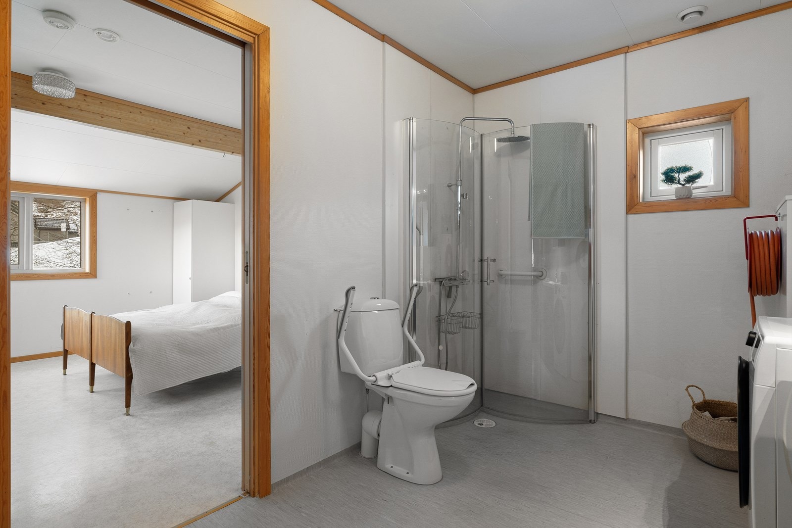 Badet er innredet med dusjdører, servant, møbler, wc, innkasset varmtvannsbereder, husbrannslange og opplegg for vaskemaskin. Galleribilde