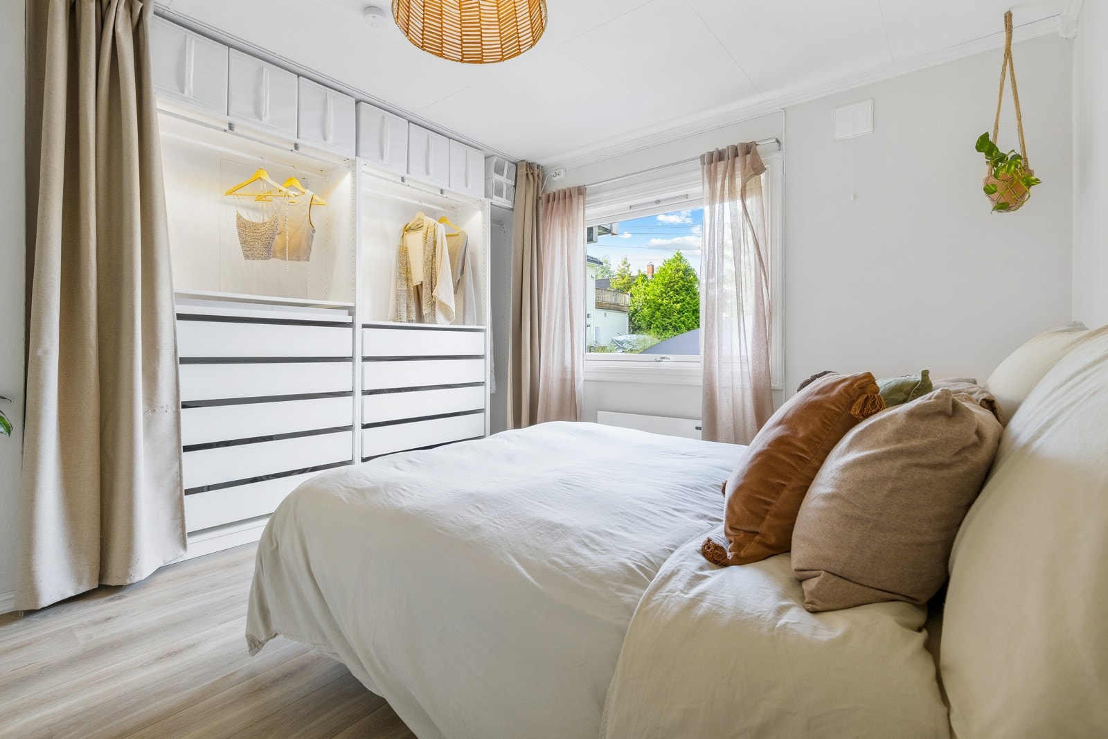 Rommet har lysmalte slette veggflater, lyspigmentert laminat på gulv og et stort vindu som slipper inn rikelig med lys. Det er satt inn en stor åpen garderobeløsning av typen Pax fra Ikea. Galleribilde