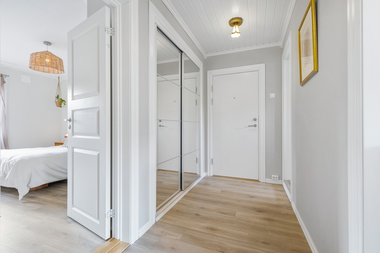 Tiltalende entre/gang med lyspigmentert laminat på gulv og integrert skyvedørsgarderobe i vegg. Rommet er holdt i lyse tidsriktige fargevalg, noe som er gjennomgående for de øvrige oppholdsrommene. Selger opplyser at ytterdøren er ny i senere tid. Galleribilde
