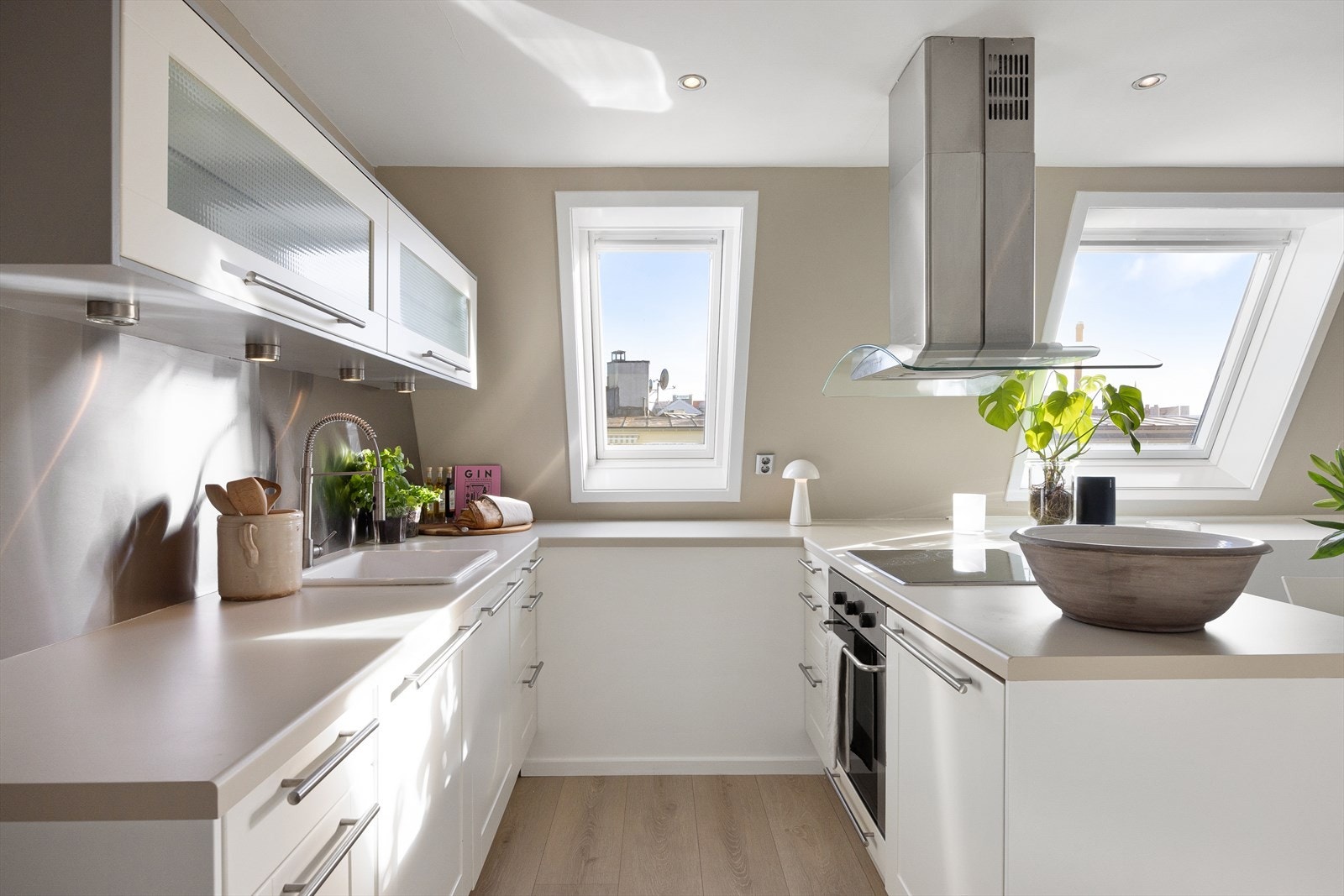 Kjøkkeninnredning med hvite fronter og laminat benkeplate. Galleribilde