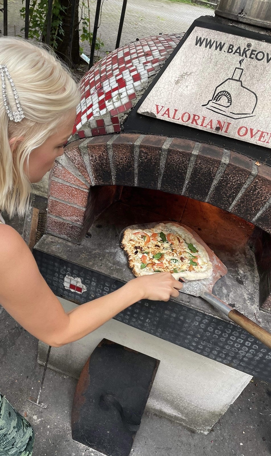 Nyt fersk pizza fra egen utendørsovn. Galleribilde