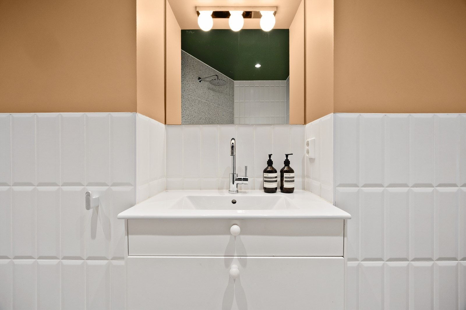 Badet er utstyrt med badekar, åpen dusj, vegghengt wc og servantinnredning med skuffer. Galleribilde