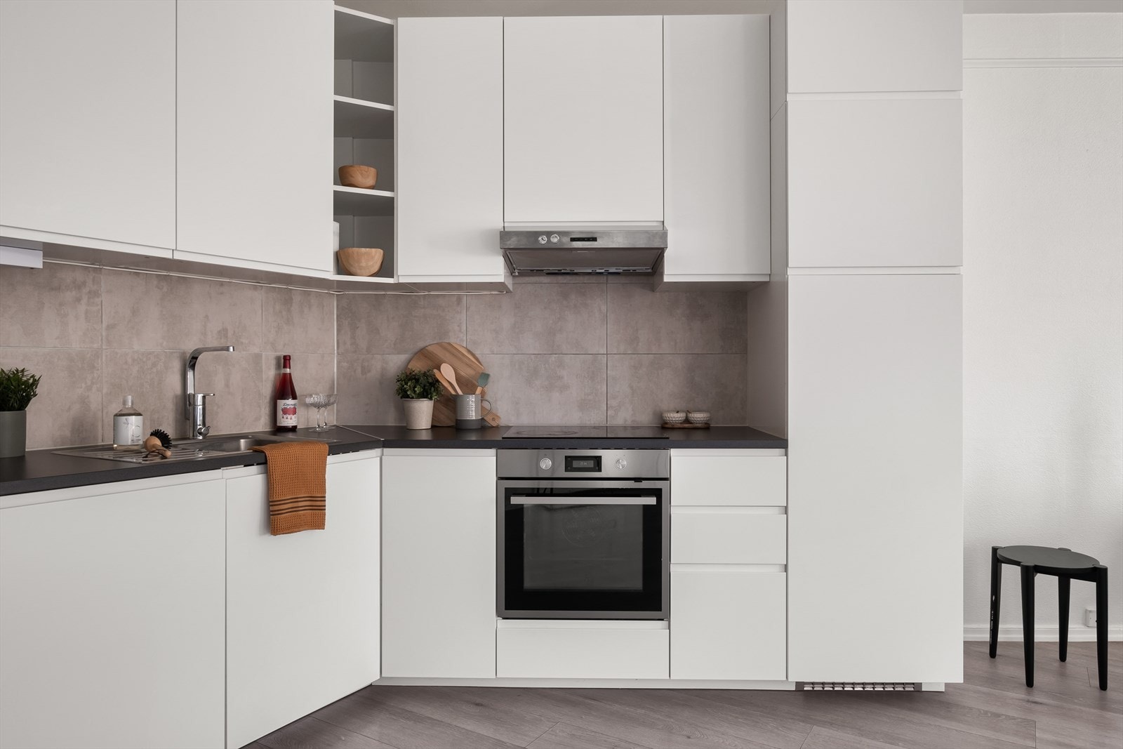 Tidsriktig glatt innredning, soft close, fliser over benk, armatur, laminat benkeplate med nedfelt stålkum og keramisk topp, integrert komfyr, oppvaskmaskin, kjøleskap. Det er kjøkkenventilator med kullfilter. Galleribilde