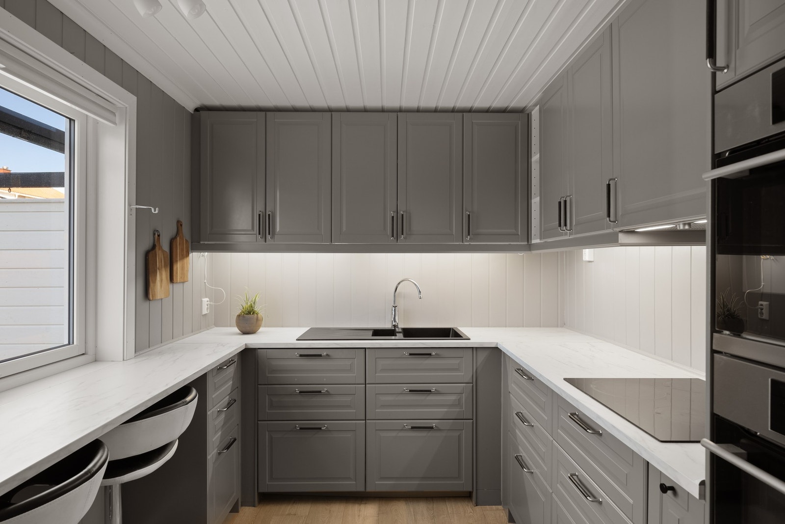 Pent og tidløst kjøkken fra 2018 i en grå utførelse med sorte detaljer. Galleribilde